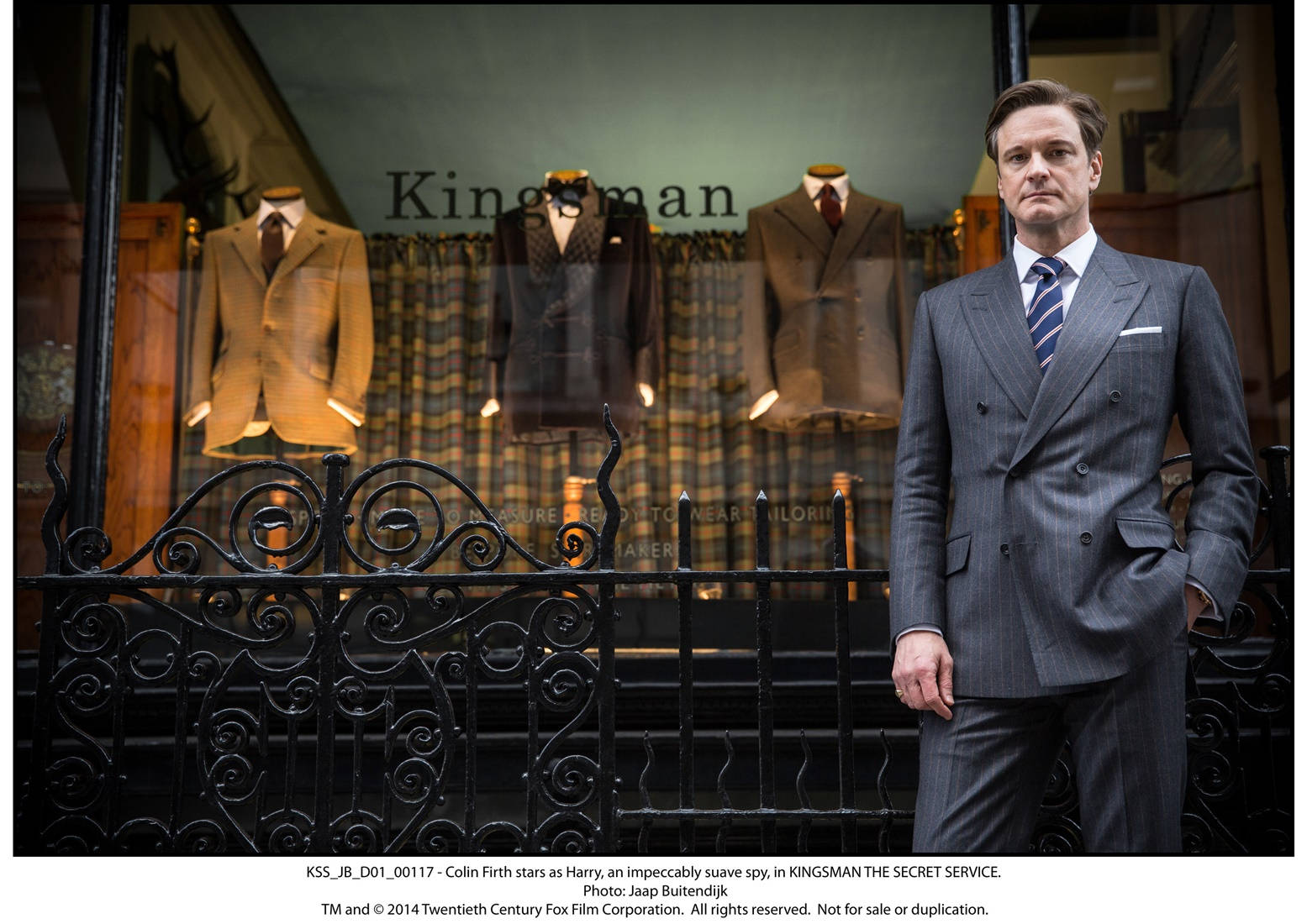 灰色西裝男子站在Kingsman裁縫店外，櫥窗內有人體模型。