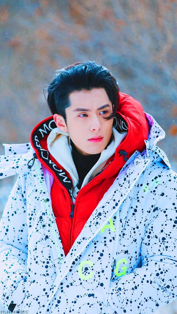 年輕男子穿著冬季外套站在雪地戶外場景中。