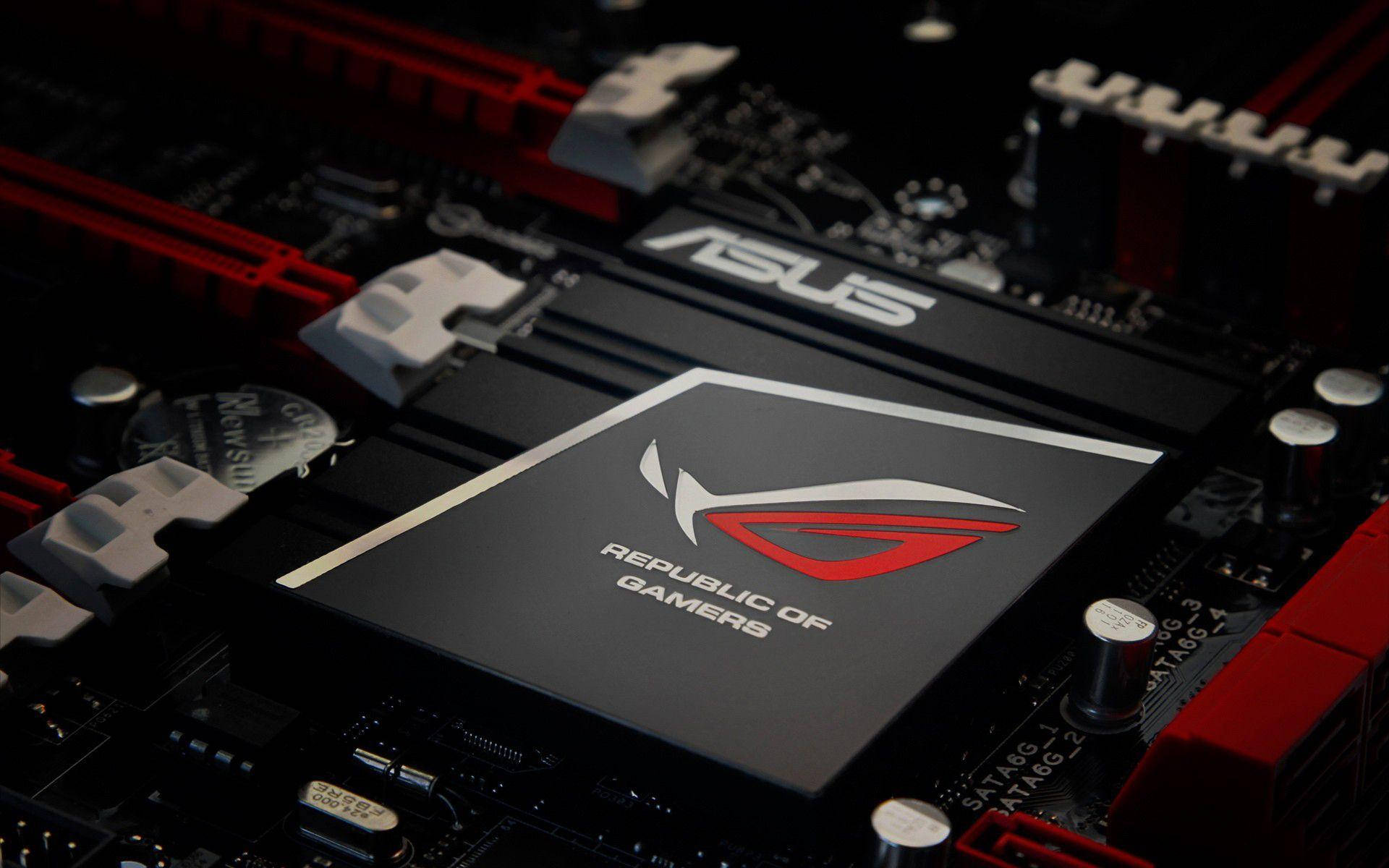 玩家共和國主機板 壁紙 — ASUS ROG 主機板特寫，紅色和黑色組件在戲劇性燈光下。