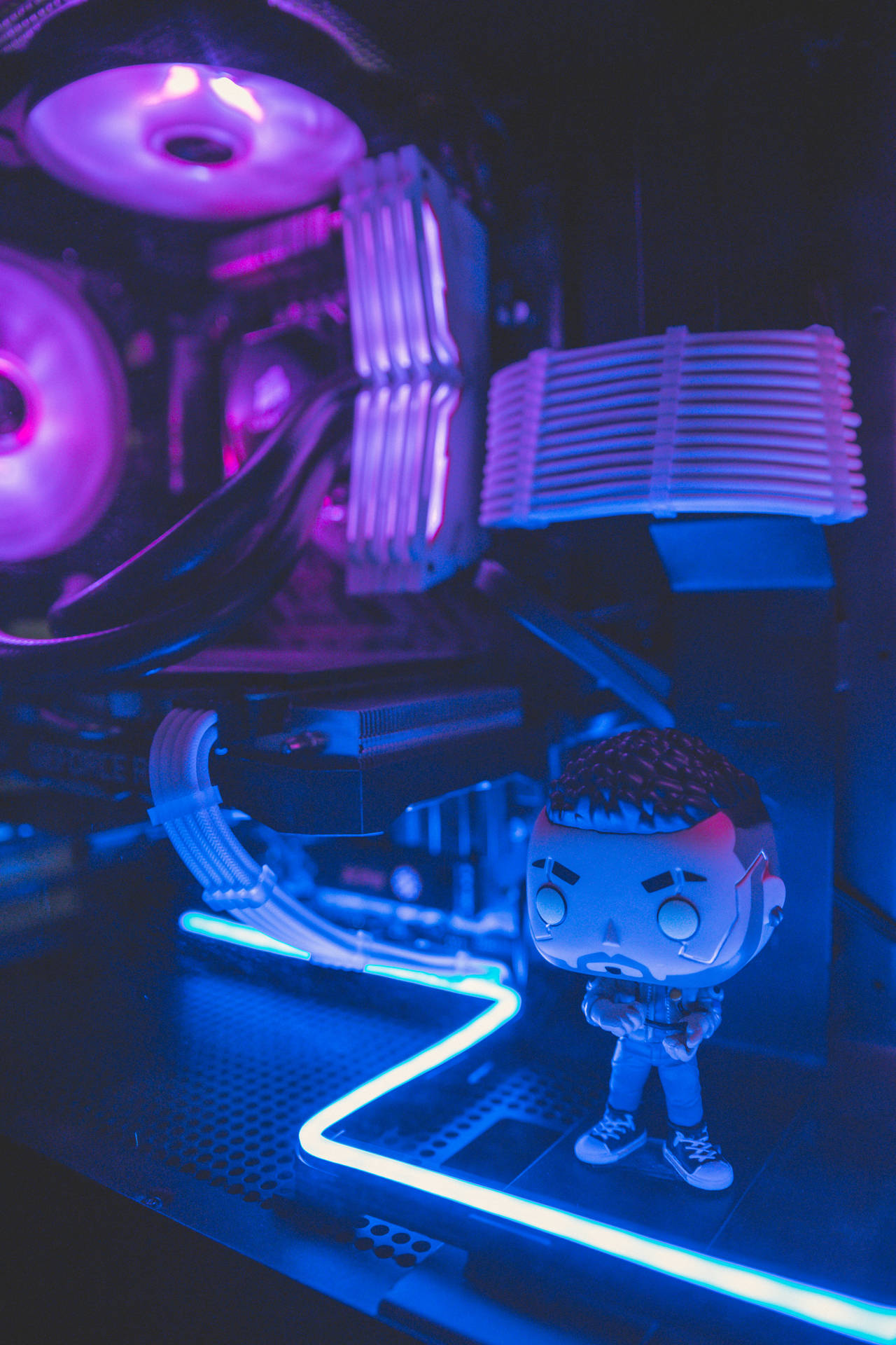 Funko Pop 公仔喺一部發光自訂遊戲電腦前面，有霓虹燈。