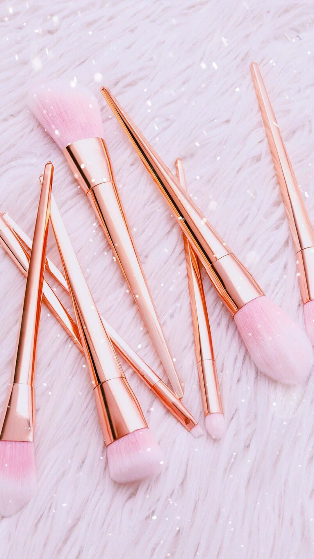 Cosmetic 桌布 壁紙 — 玫瑰金色化妝掃配以柔軟粉紅色刷毛，放置在灑滿閃粉的蓬鬆白色表面上。
