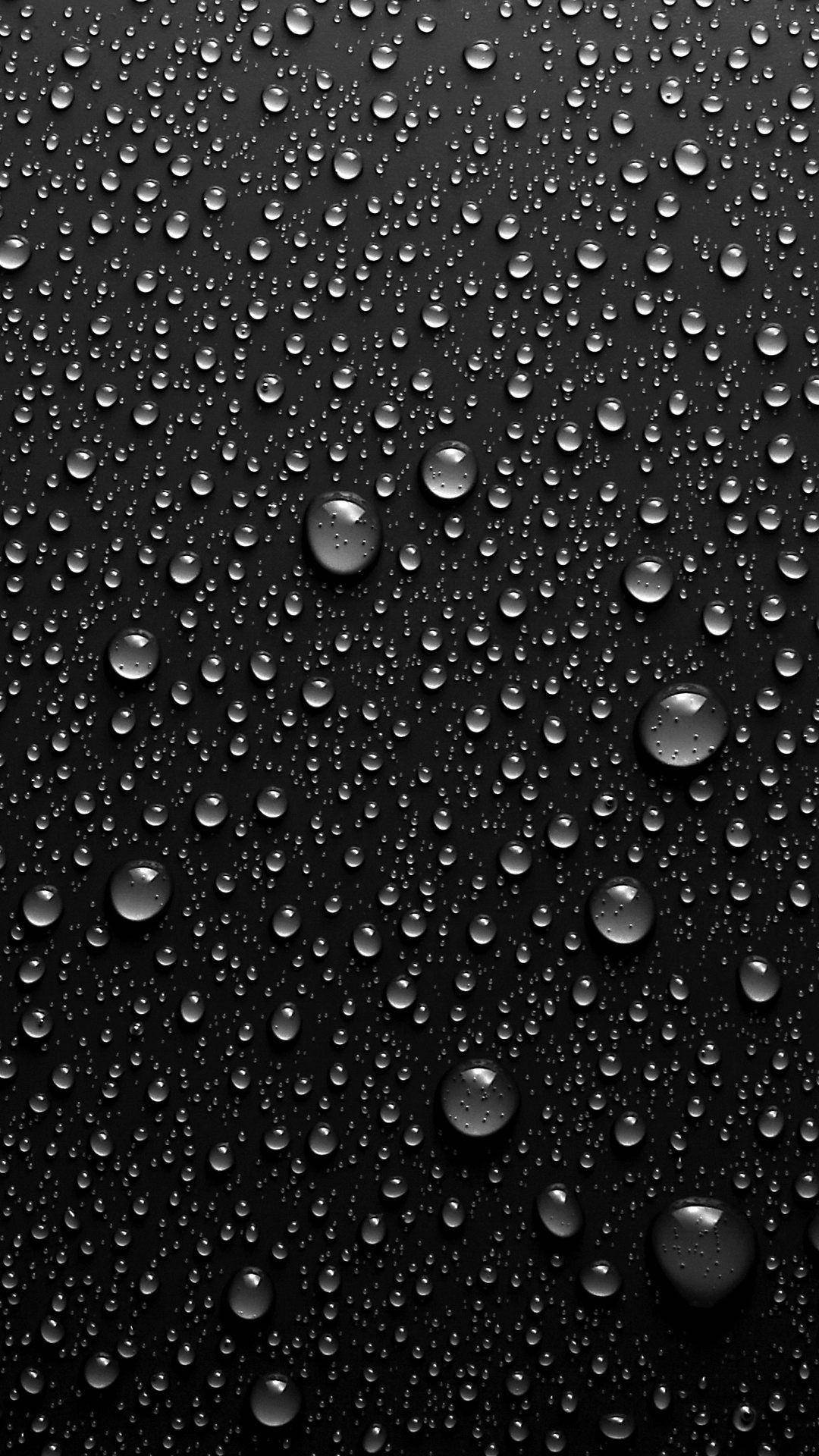 玻璃上的水珠 iPhone 8 生動壁紙 壁紙 — 閃亮的水滴依附在光滑的黑色表面上，營造出極簡的單色紋理。