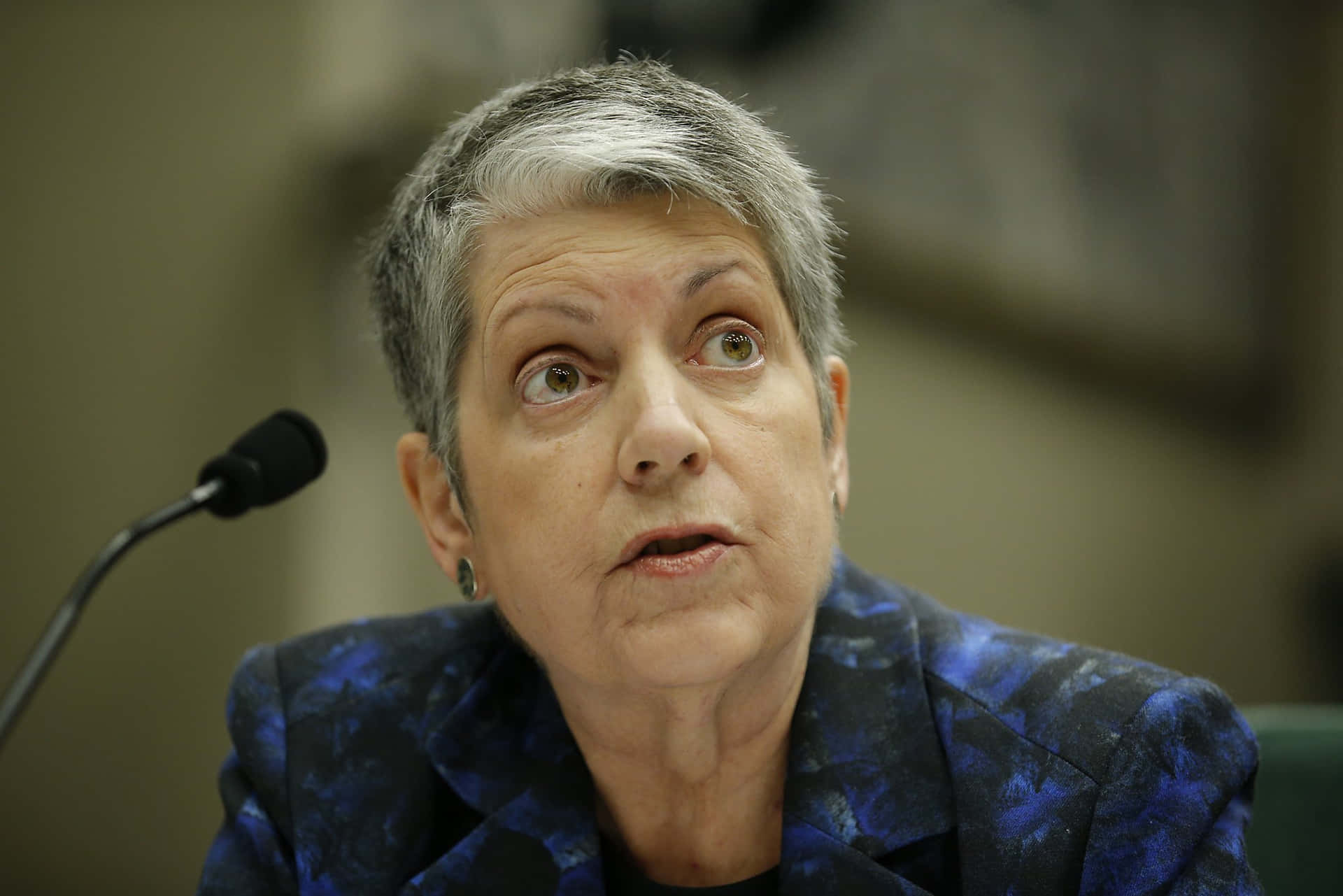 穿藍色西裝外套的女性在會議中抬頭露出驚訝表情