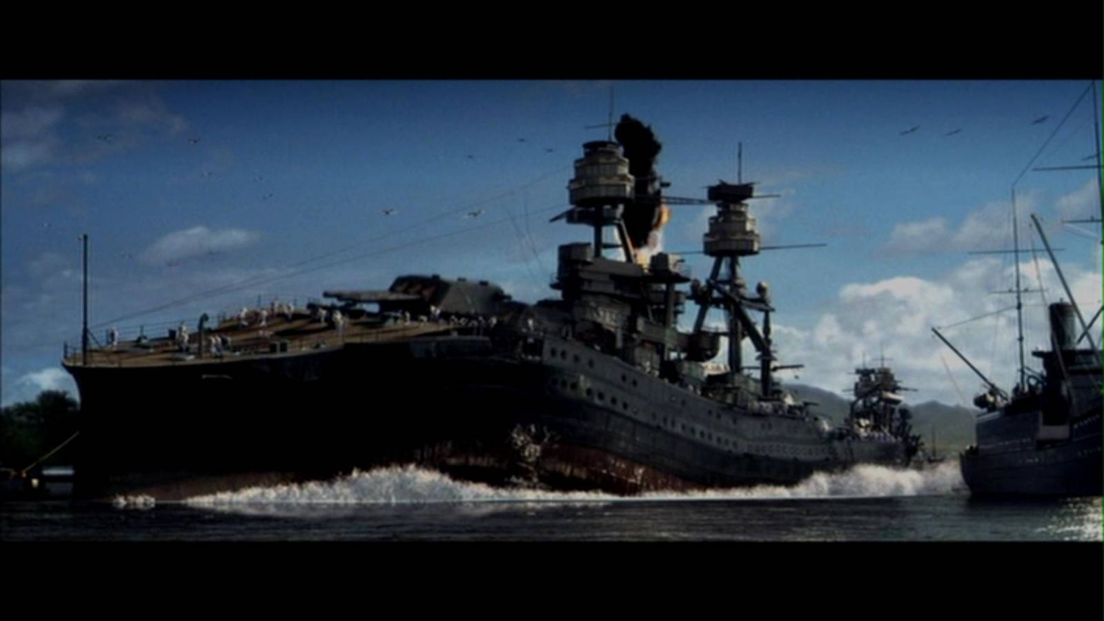 珍珠港的USS Arizona BB-39戰艦 壁紙 — 一艘巨大的戰艦在波濤洶湧的海面上航行，天空湛藍，白雲點綴，遠處有山巒。
