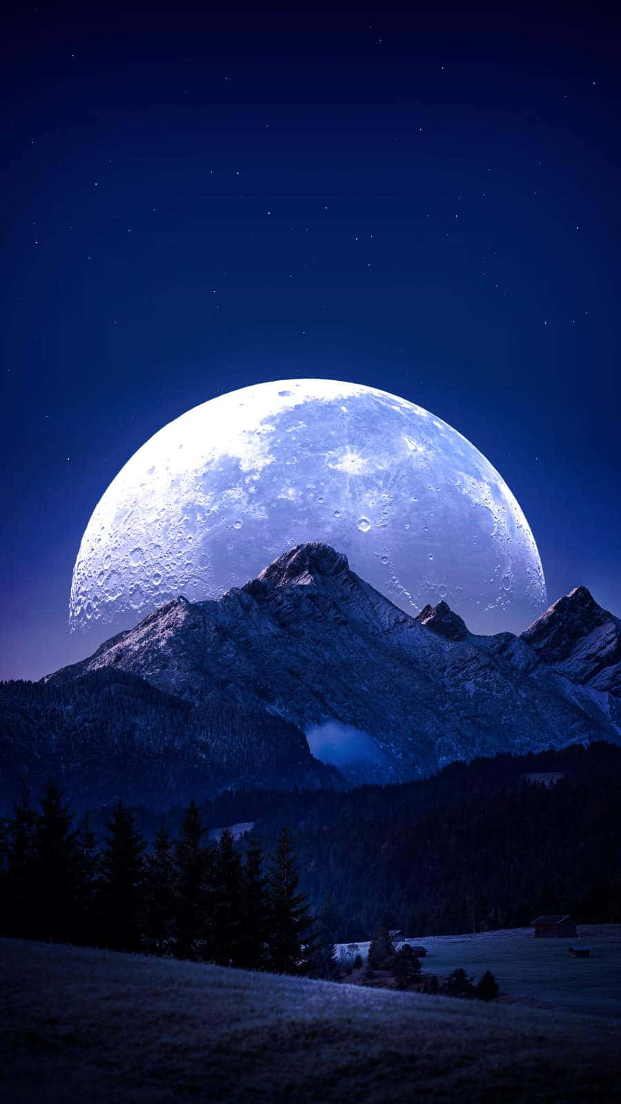 珠峰月影 iPhone 壁紙 — 一個巨大的發光月亮在繁星點點的夜空下從雪山後升起。