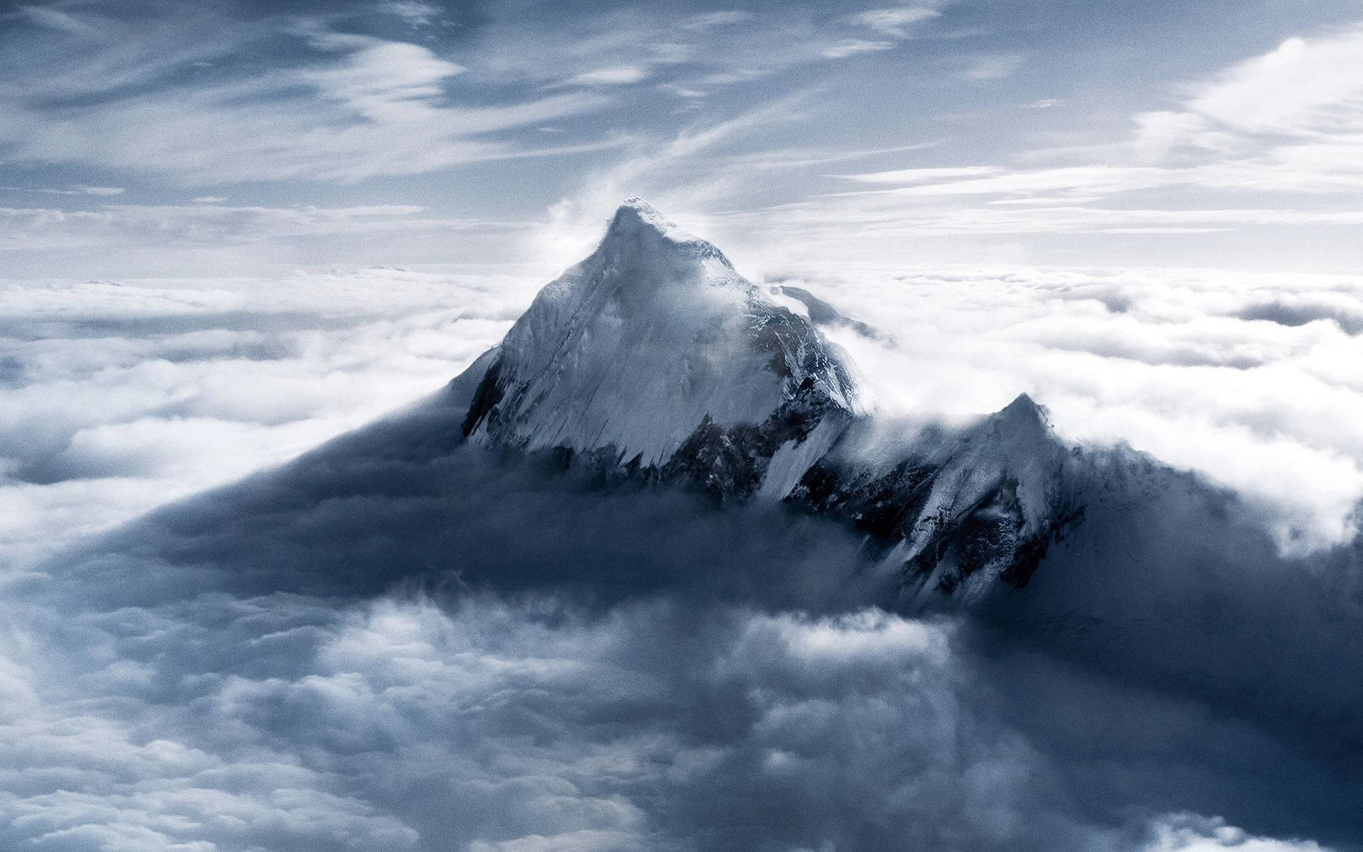 白雪覆蓋的山峰聳立在廣闊的雲海之上。