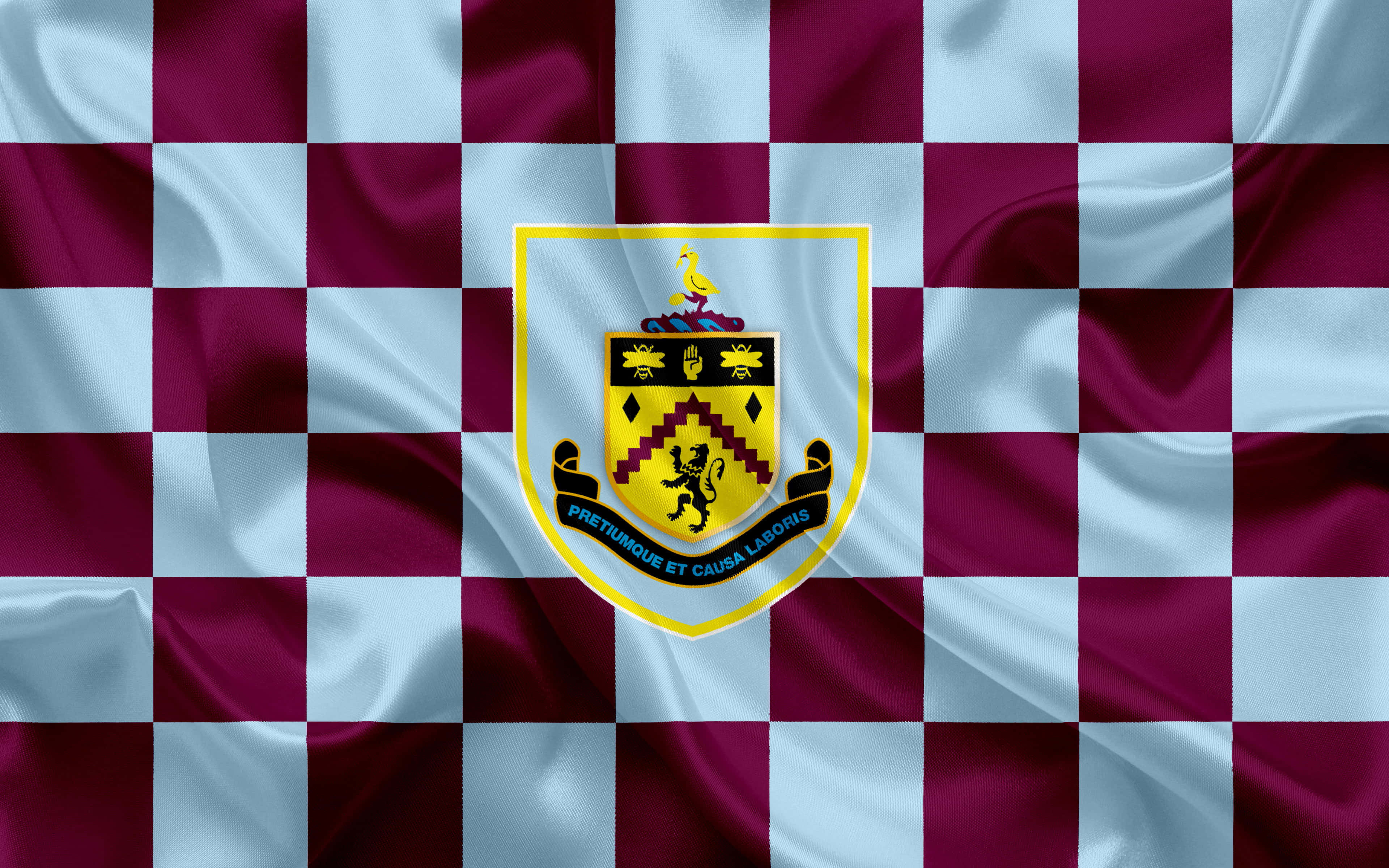Burnley Fc 桌布 壁紙 — 班士利足球會旗幟的特寫，帶有栗色和淺藍色格紋布料及中央徽章。