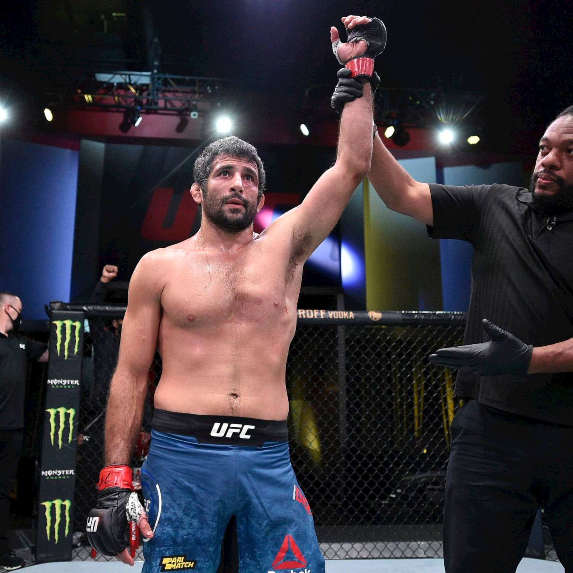 UFC拳手贏得比賽，裁判舉起他的手宣告勝利。