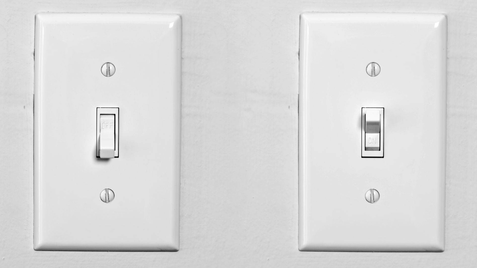 現代 Insteon ToggleLinc 電燈開關 壁紙 — 兩個白色燈掣並排安裝在帶有螺絲和微妙陰影的紋理牆壁上。