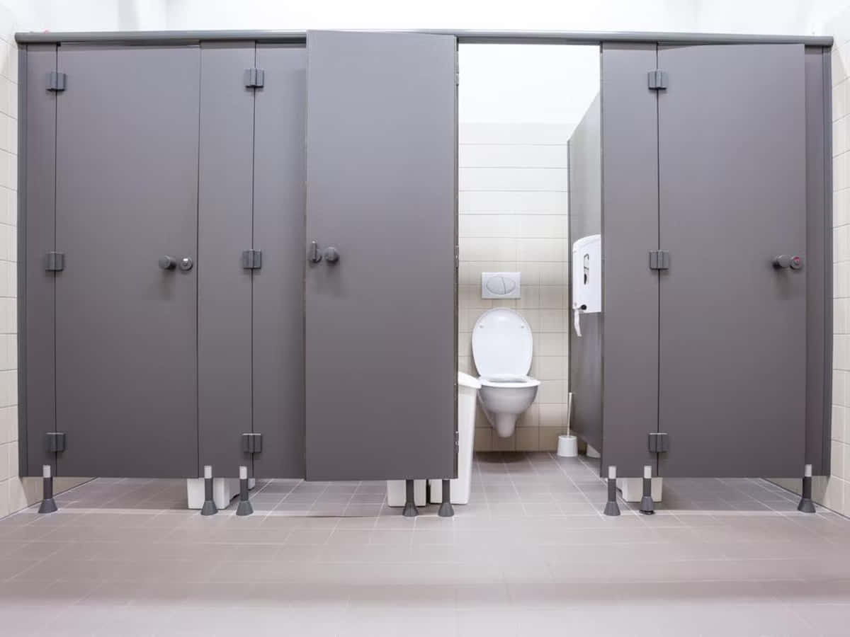 Toilet 桌布 壁紙 — 現代公共洗手間，設有灰色隔間及白色瓷磚牆壁和地板。