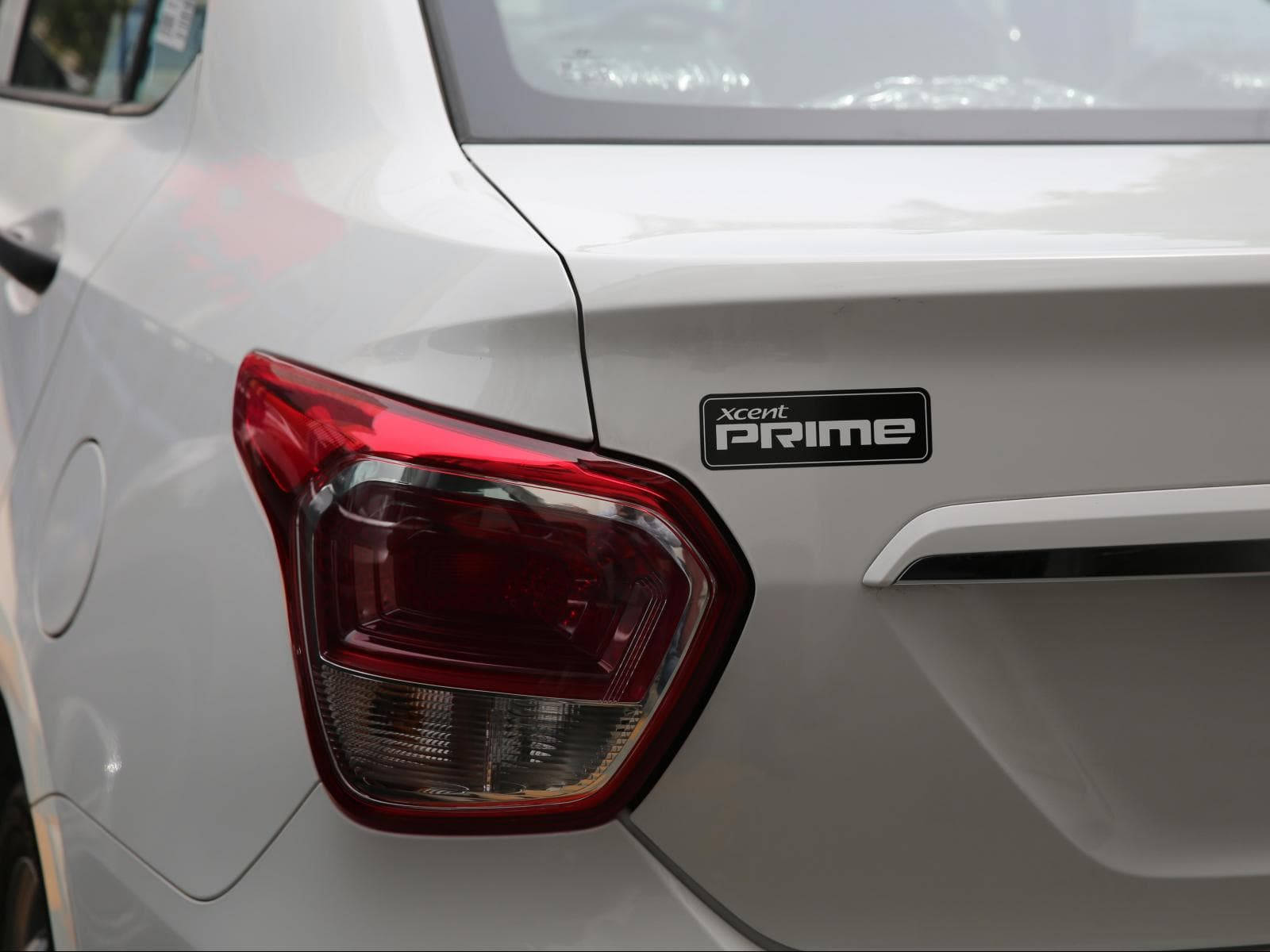 白色汽車尾部的特寫，尾燈和 xcent prime 徽章。