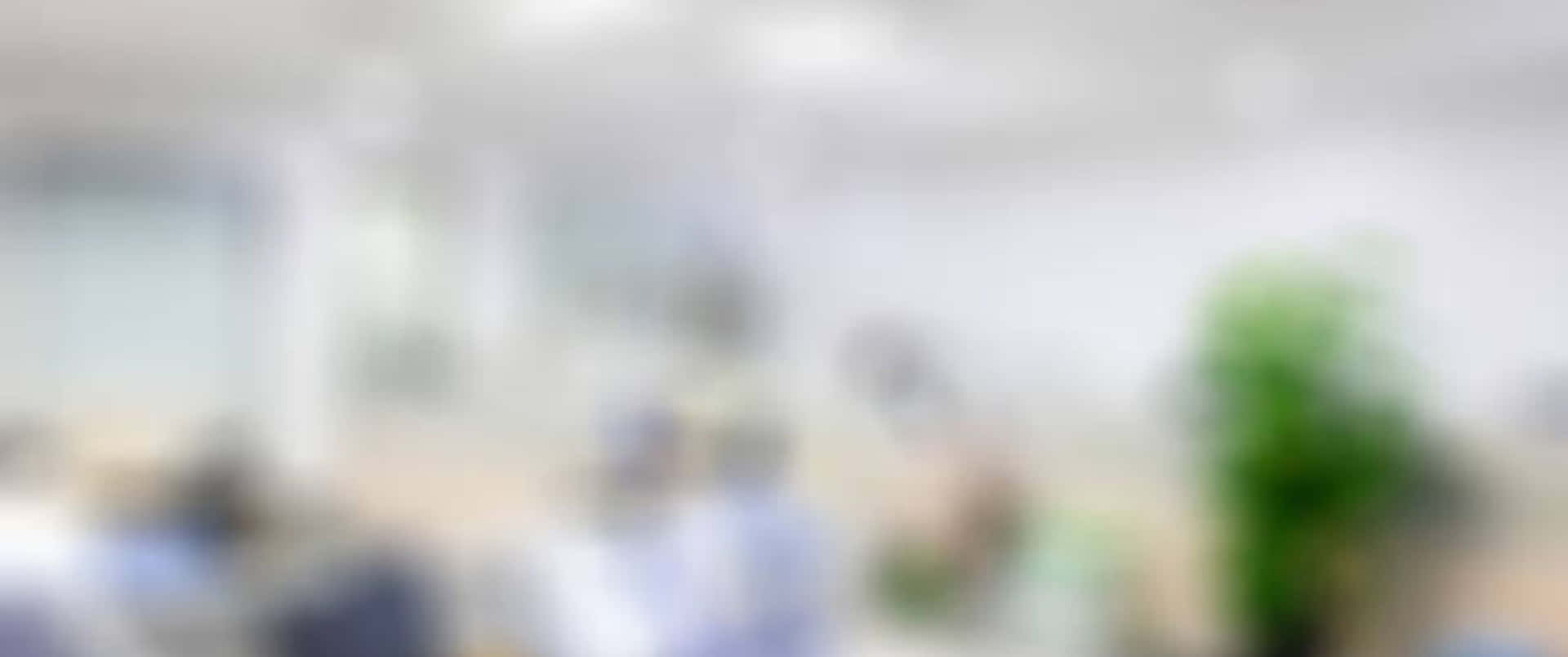 模糊的辦公人員和現代工作空間中的綠色植物視圖。