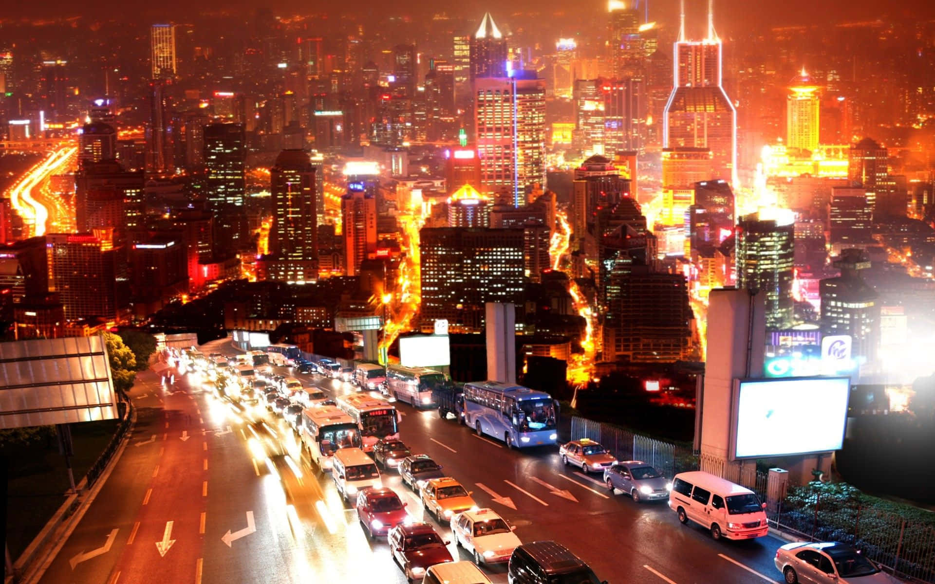 夜晚繁忙的城市，發光的建築物和高速公路上行駛的汽車。