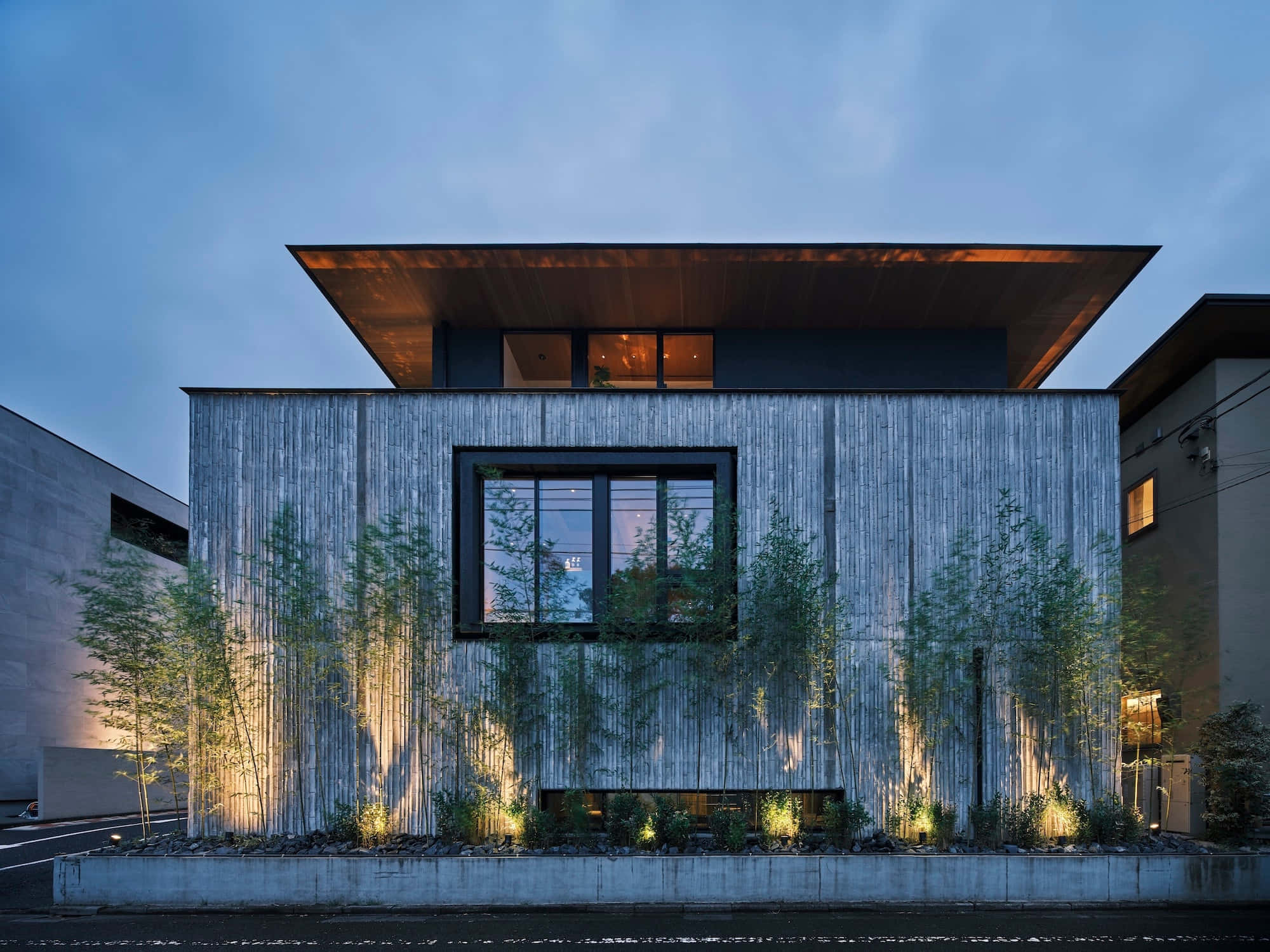 Minimalist Architecture 桌布 壁紙 — 現代房屋，木條外牆，發光的窗戶被黃昏時照亮的竹子環繞。