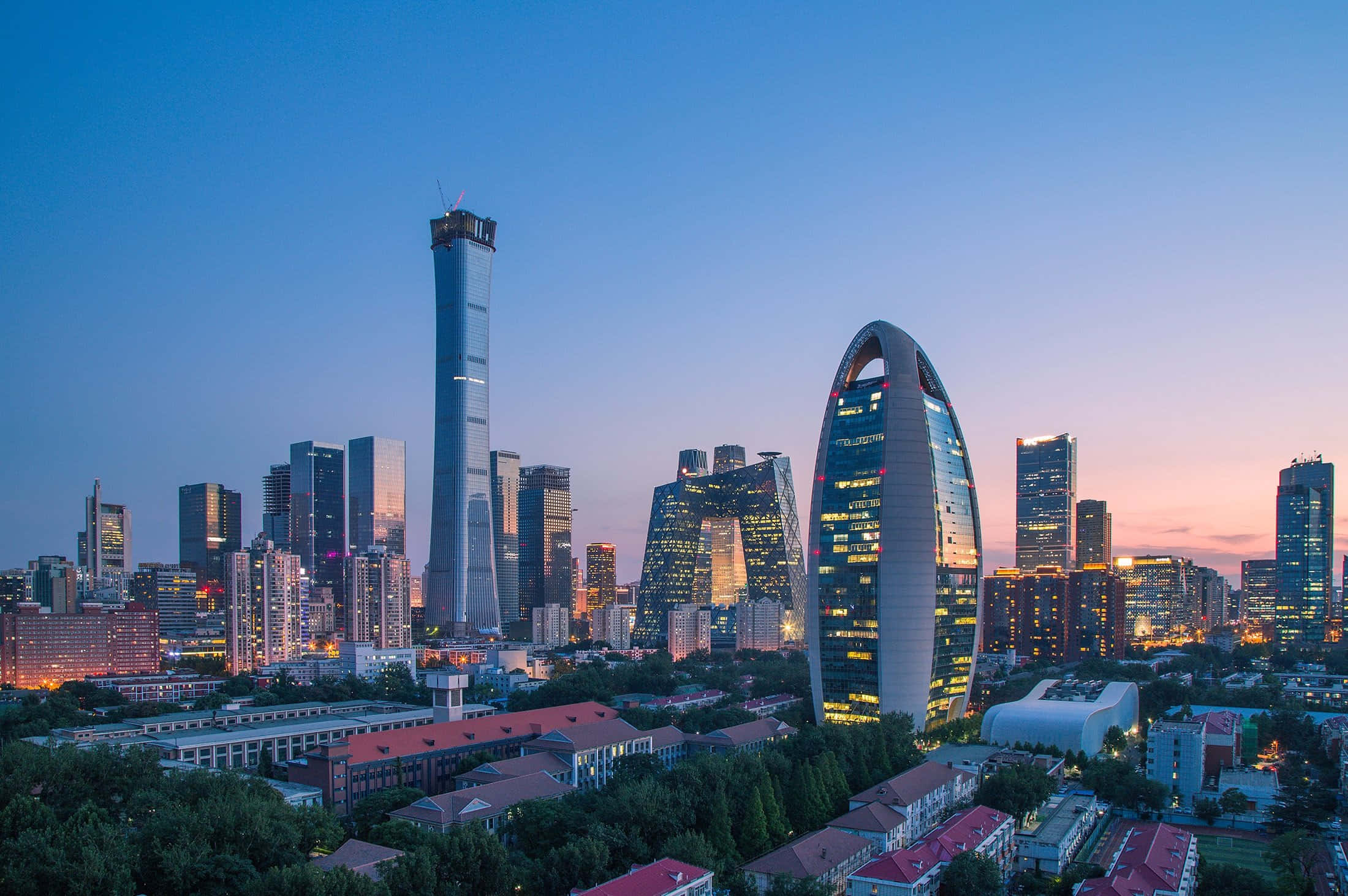 Beautiful City 桌布 壁紙 — 現代摩天大樓在暮色中閃耀，城市燈光點亮都市天際線。