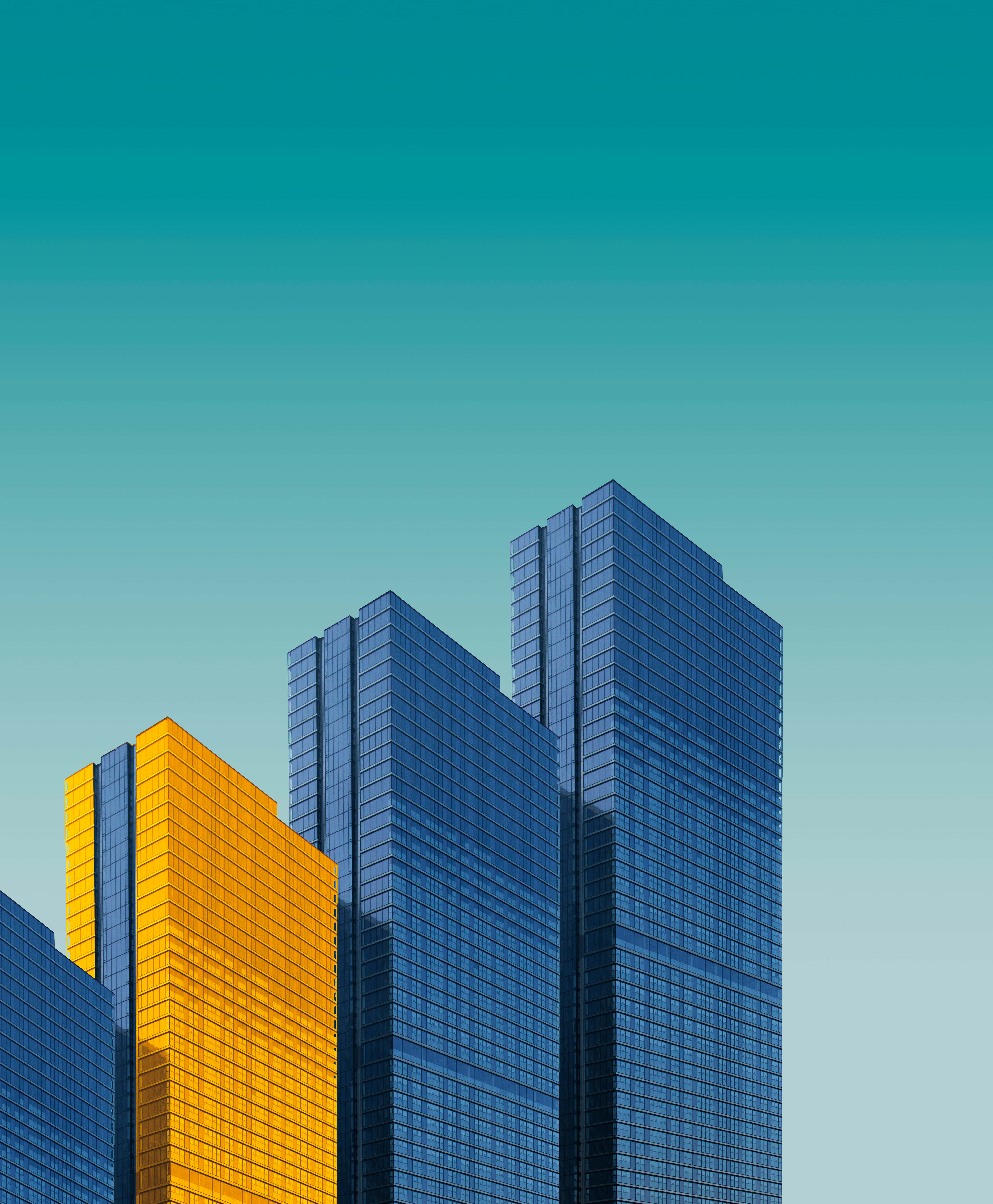 3d City 桌布 壁紙 — 現代玻璃摩天大樓在漸變青綠色天空的映襯下拔地而起，其中一棟建築閃耀著金色光芒。