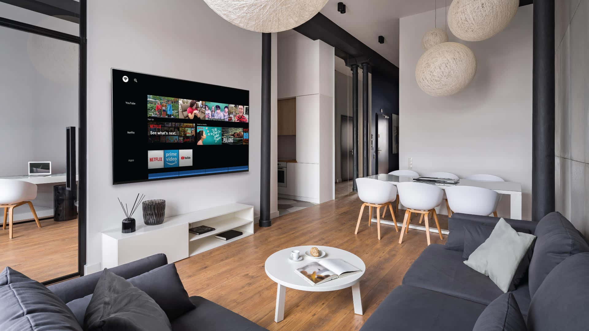 Home Entertainment 桌布 壁紙 — 現代簡約客廳，配有灰色沙發、白色餐椅和大屏幕電視，顯示串流應用程式。