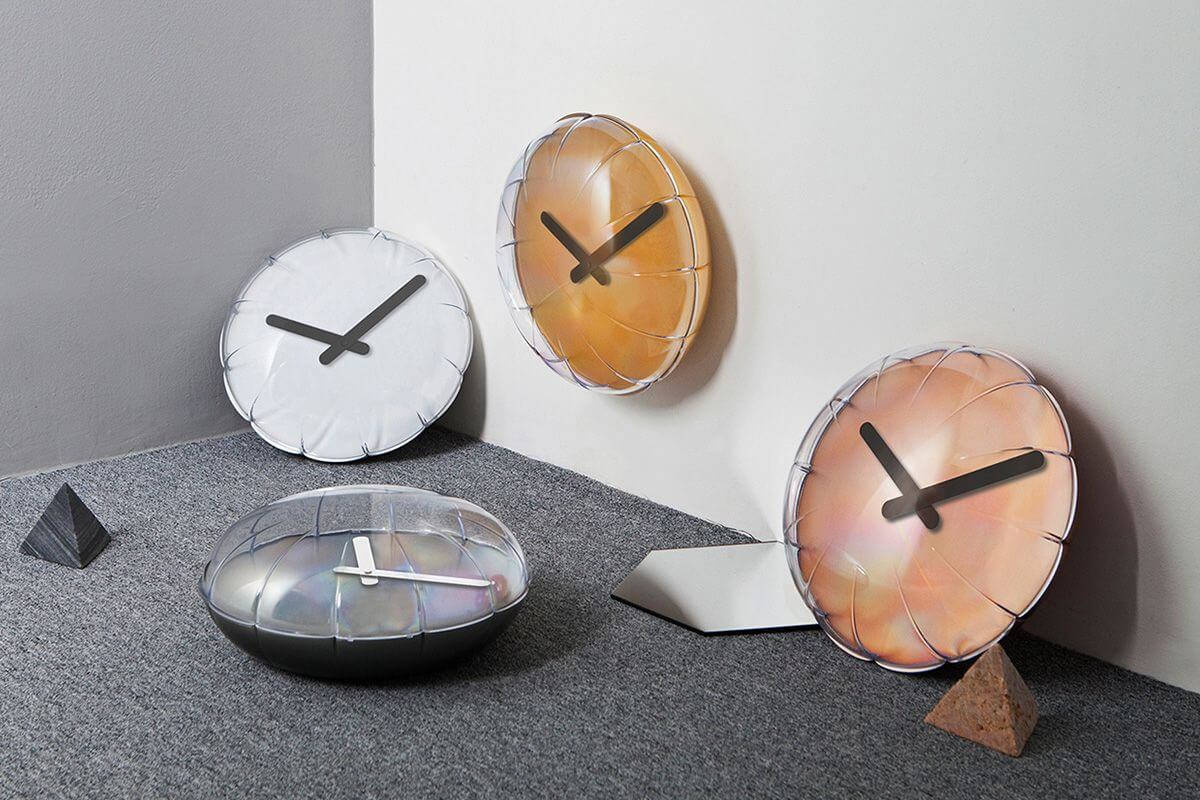 Clock 桌布 壁紙 — 現代簡約時鐘，配以半透明外殼和黑色指針，展示在灰色角落環境中。