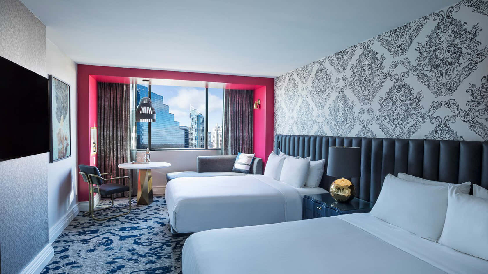 Hotel Room 桌布 壁紙 — 現代酒店客房，配備兩張床、圖案地毯和粉紅色特色牆，透過大窗戶可欣賞城市天際線。