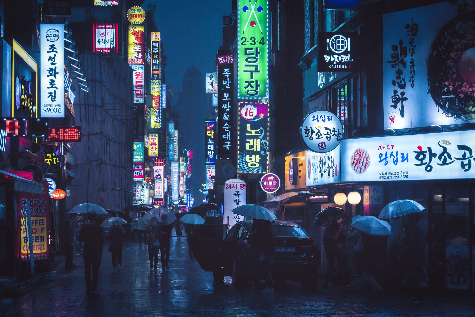 繁華韓國城市的夜雨，閃爍的霓虹燈招牌和撐傘的人們。