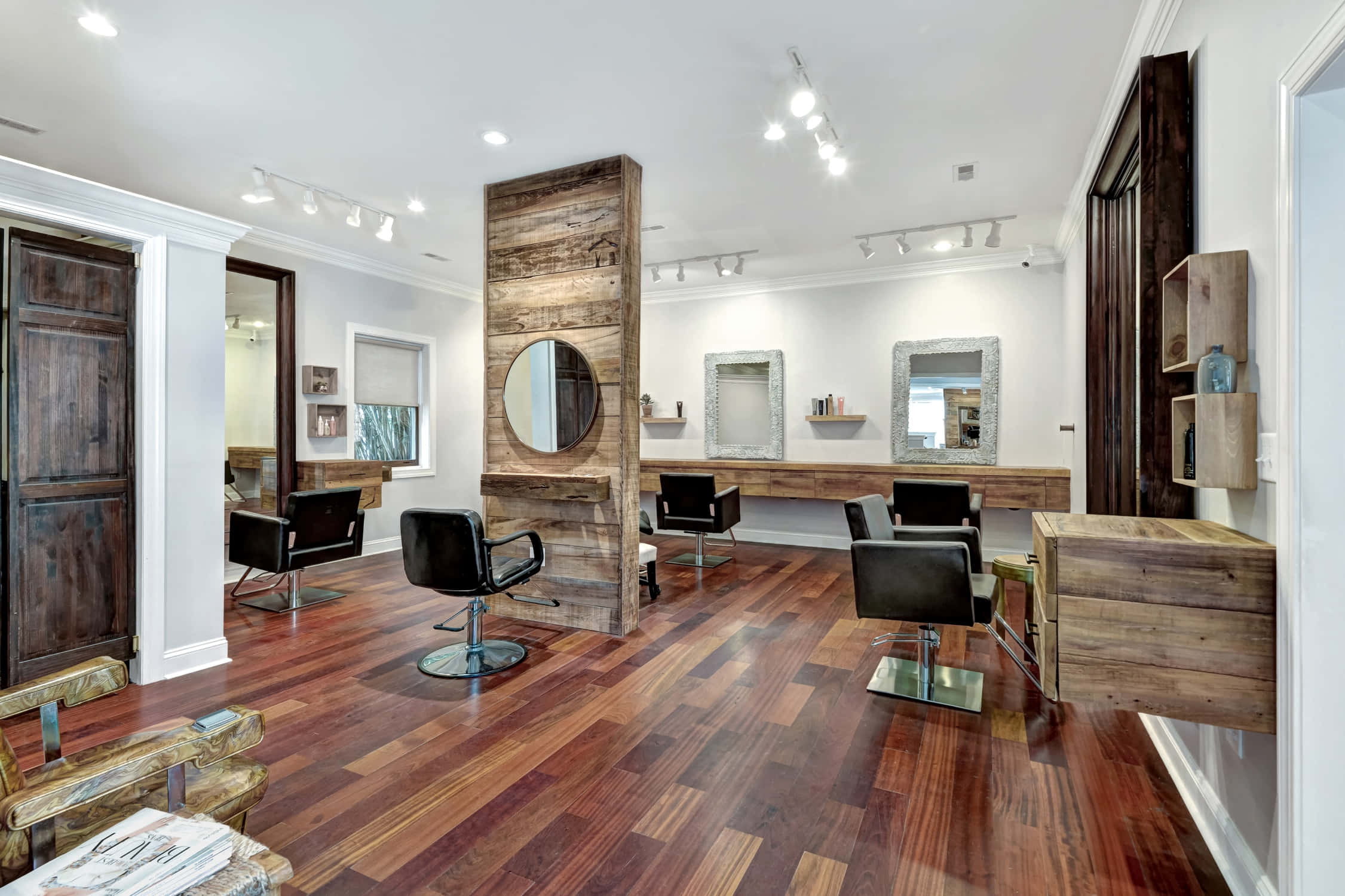 Hair Salon 桌布 壁紙 — 現代髮廊，擁有豐富的木地板、鄉村風木質裝飾和黑色造型椅，在明亮的軌道燈光下。