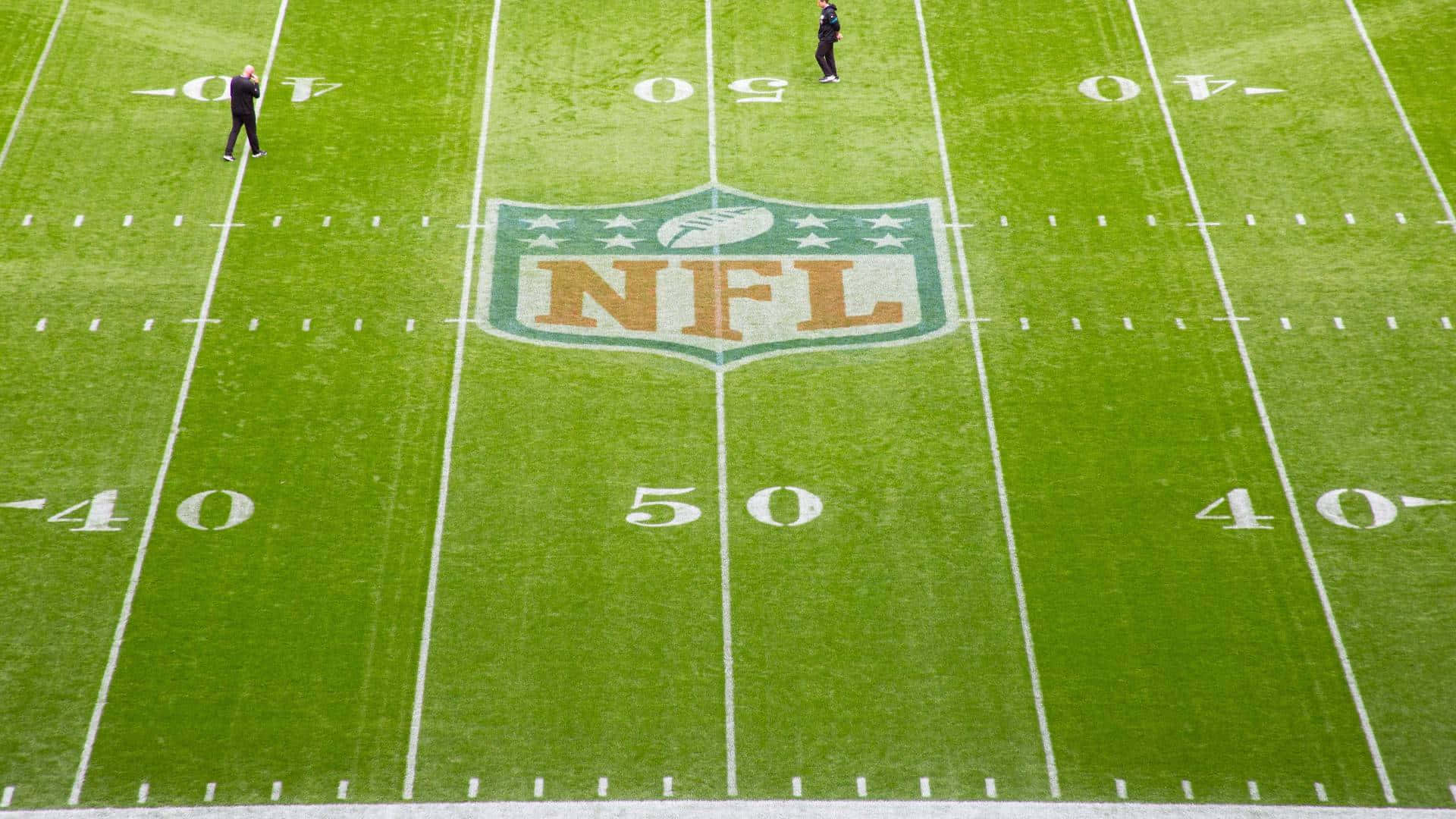 兩人在NFL足球場上靠近50碼線。