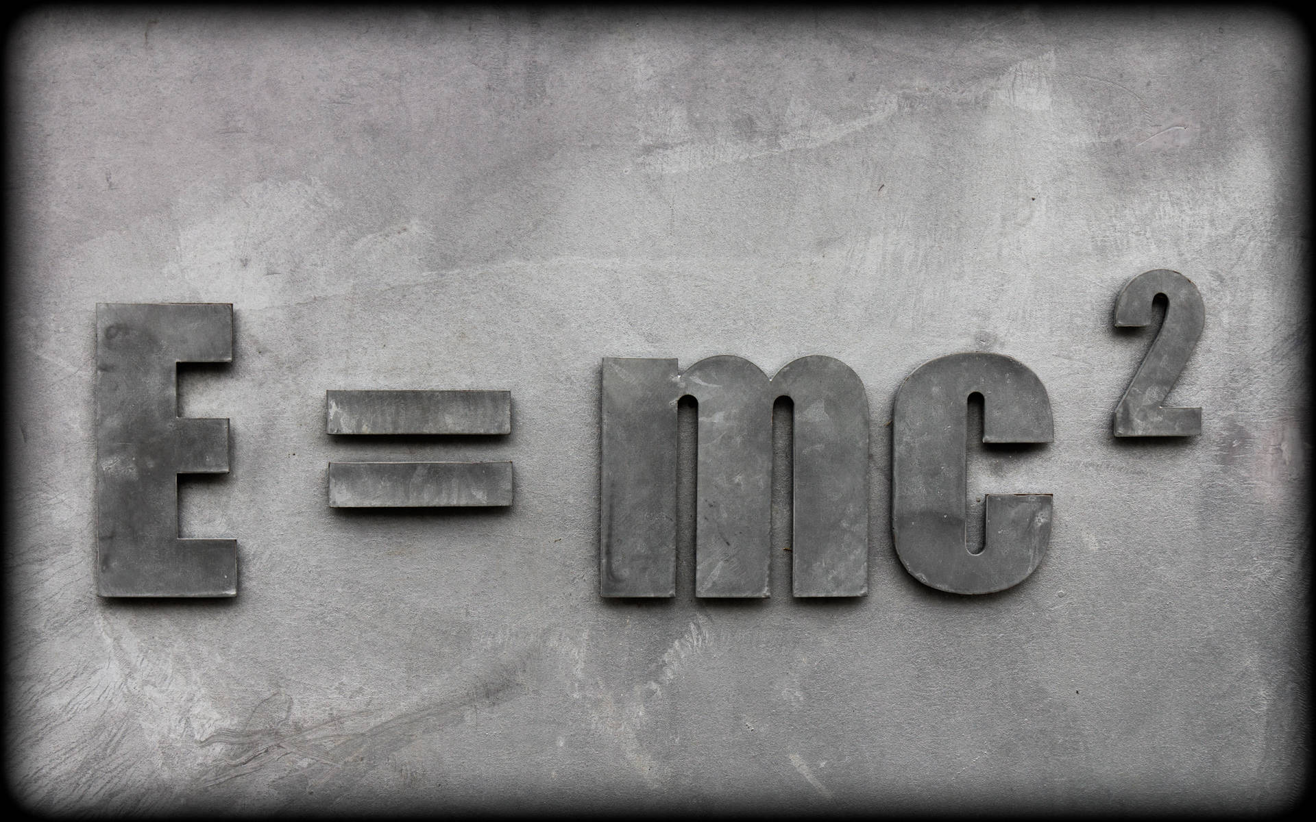 混凝土牆上凸起的金屬字母顯示E=mc²方程式。