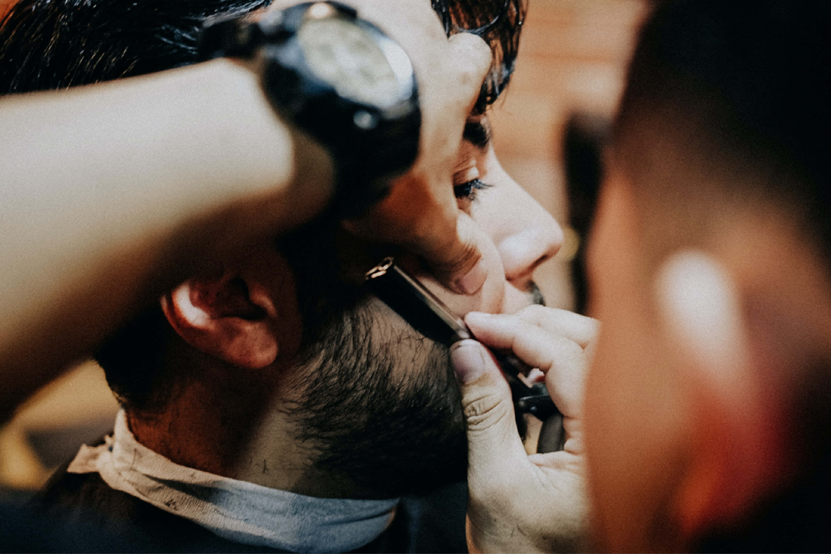 Barber 桌布 壁紙 — 理髮師在溫暖燈光的理髮店內，用直剃刀仔細修剪男士鬍鬚的特寫。
