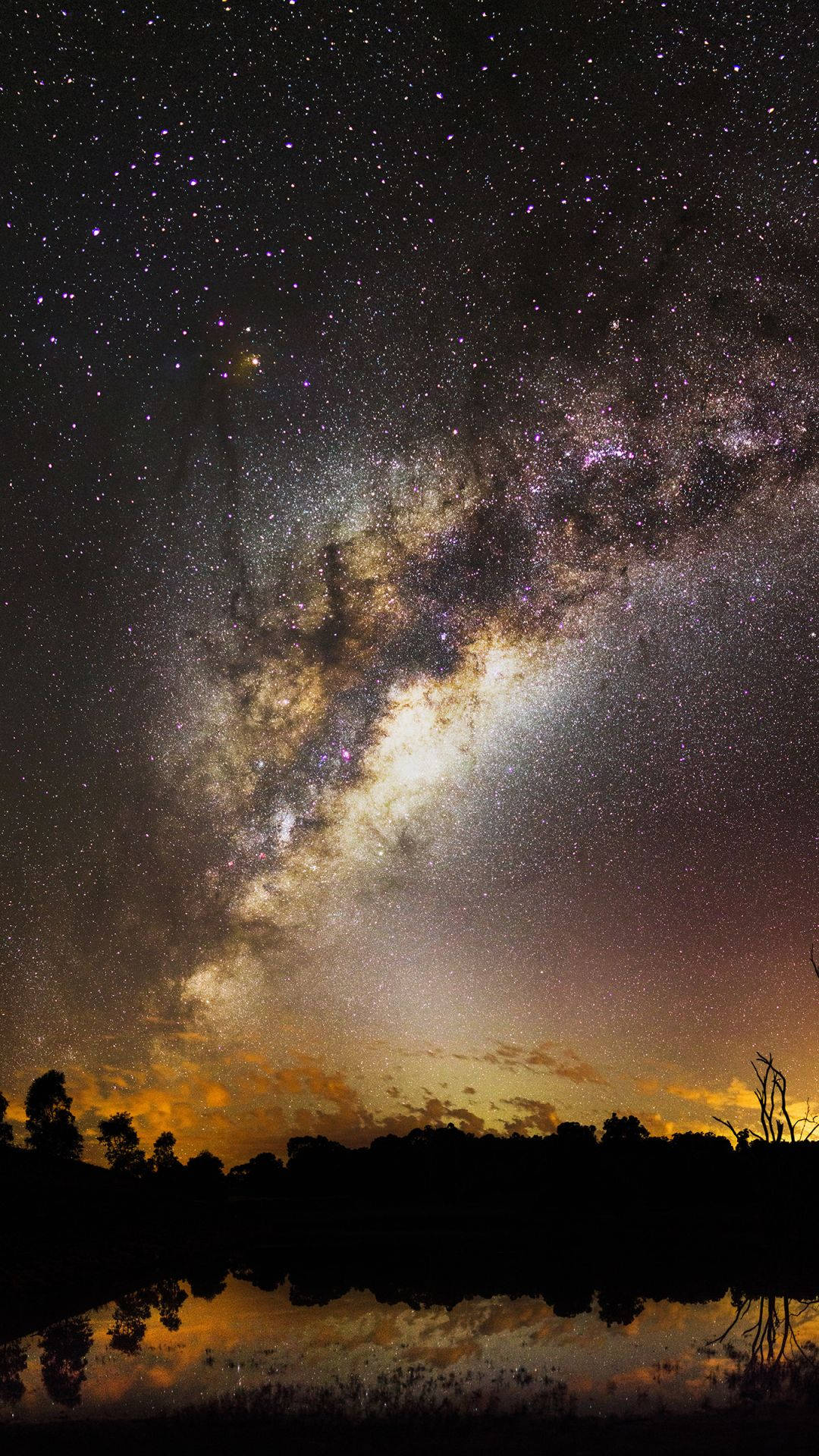 銀河系在繁星點點的夜空下倒映在水中。