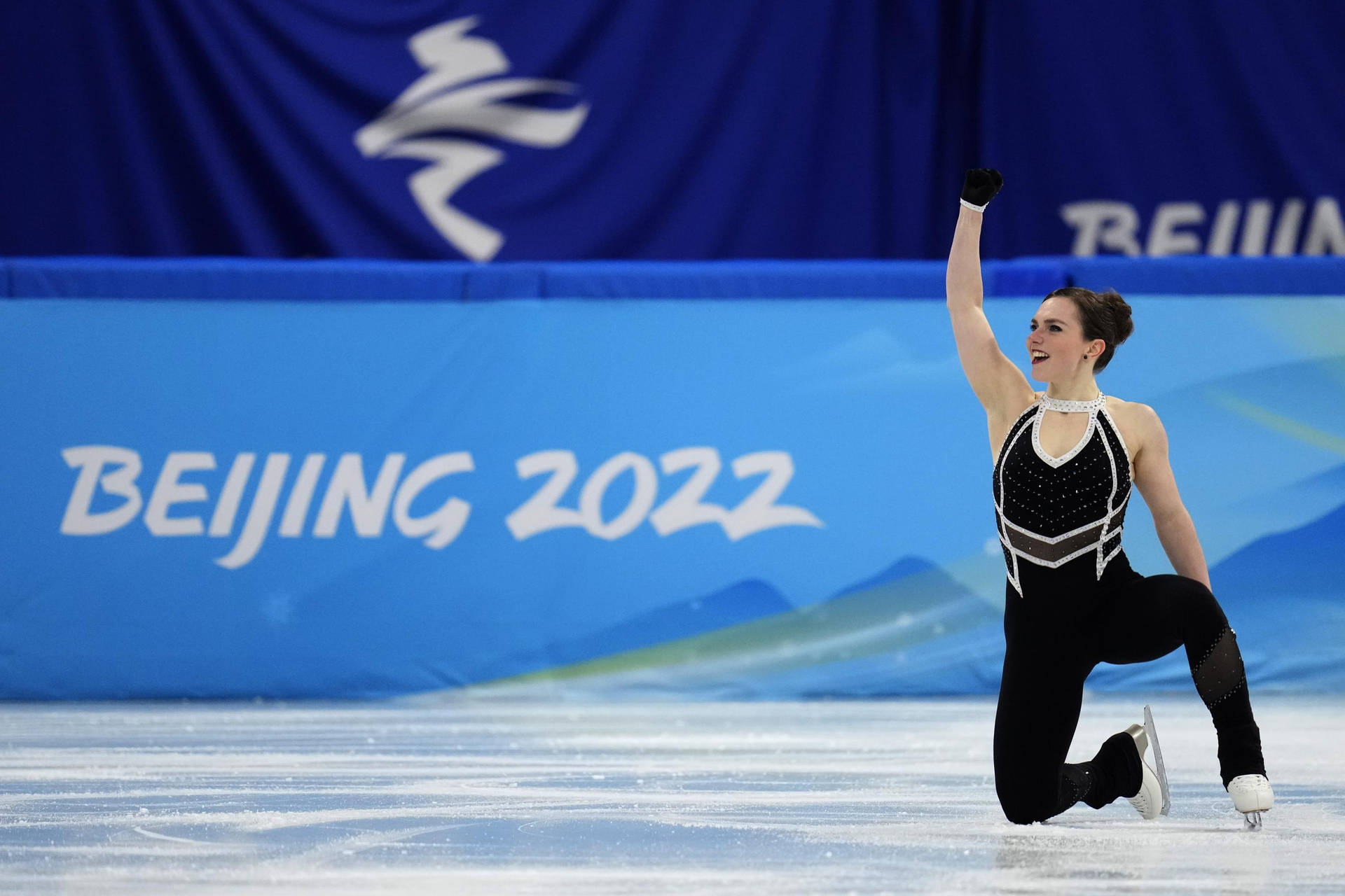 瑞典花式滑冰選手約瑟芬·塔爾耶加德於2022年冬季奧運會 壁紙 — 一位女性花樣滑冰運動員在北京2022年冬奧會上高舉一隻手臂，在冰上勝利慶祝。