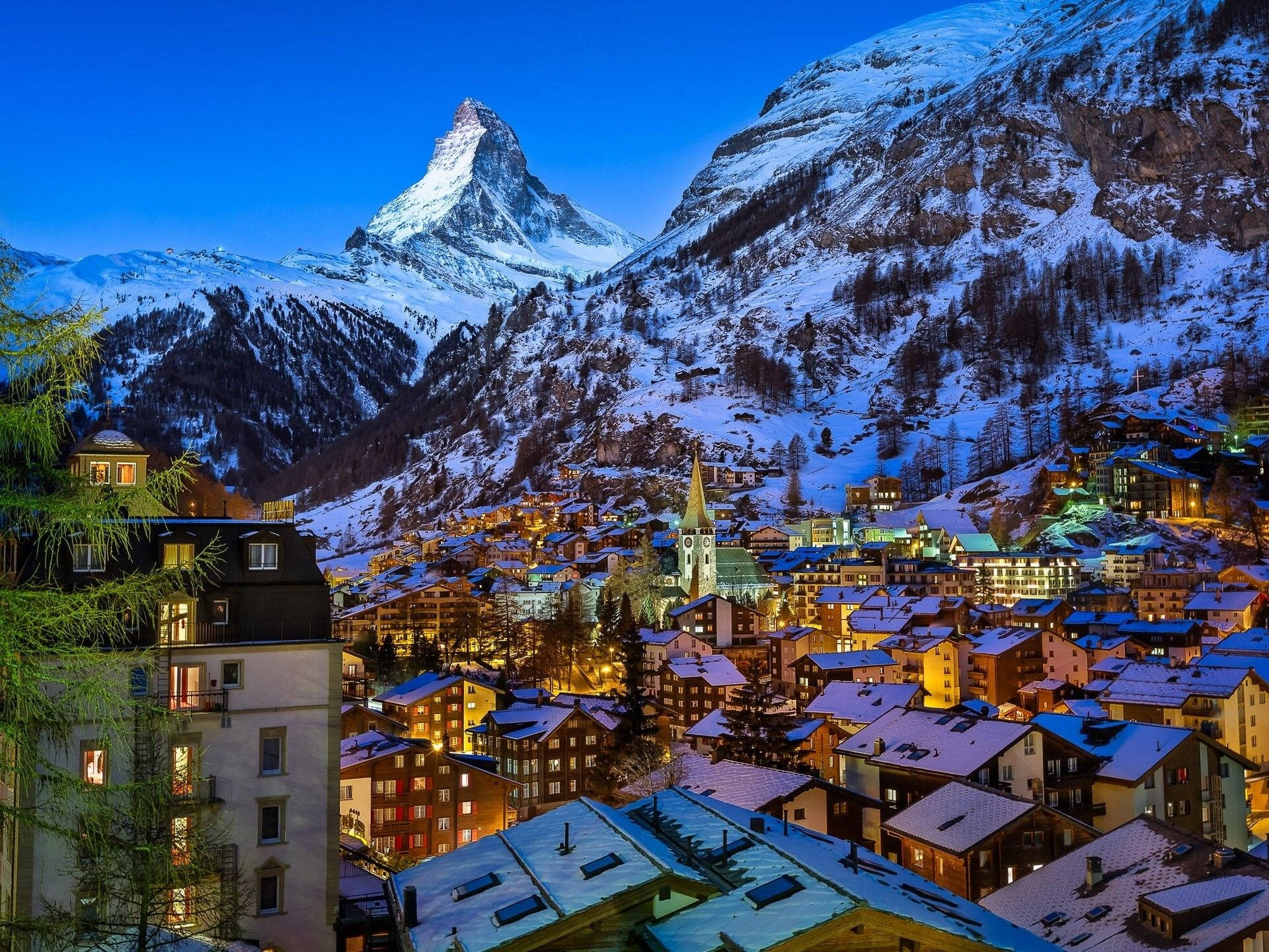 瑞士阿爾卑斯山冬季風景 壁紙 — 暮色天空下，閃耀的馬特洪峰山腳下，白雪覆蓋的山村。