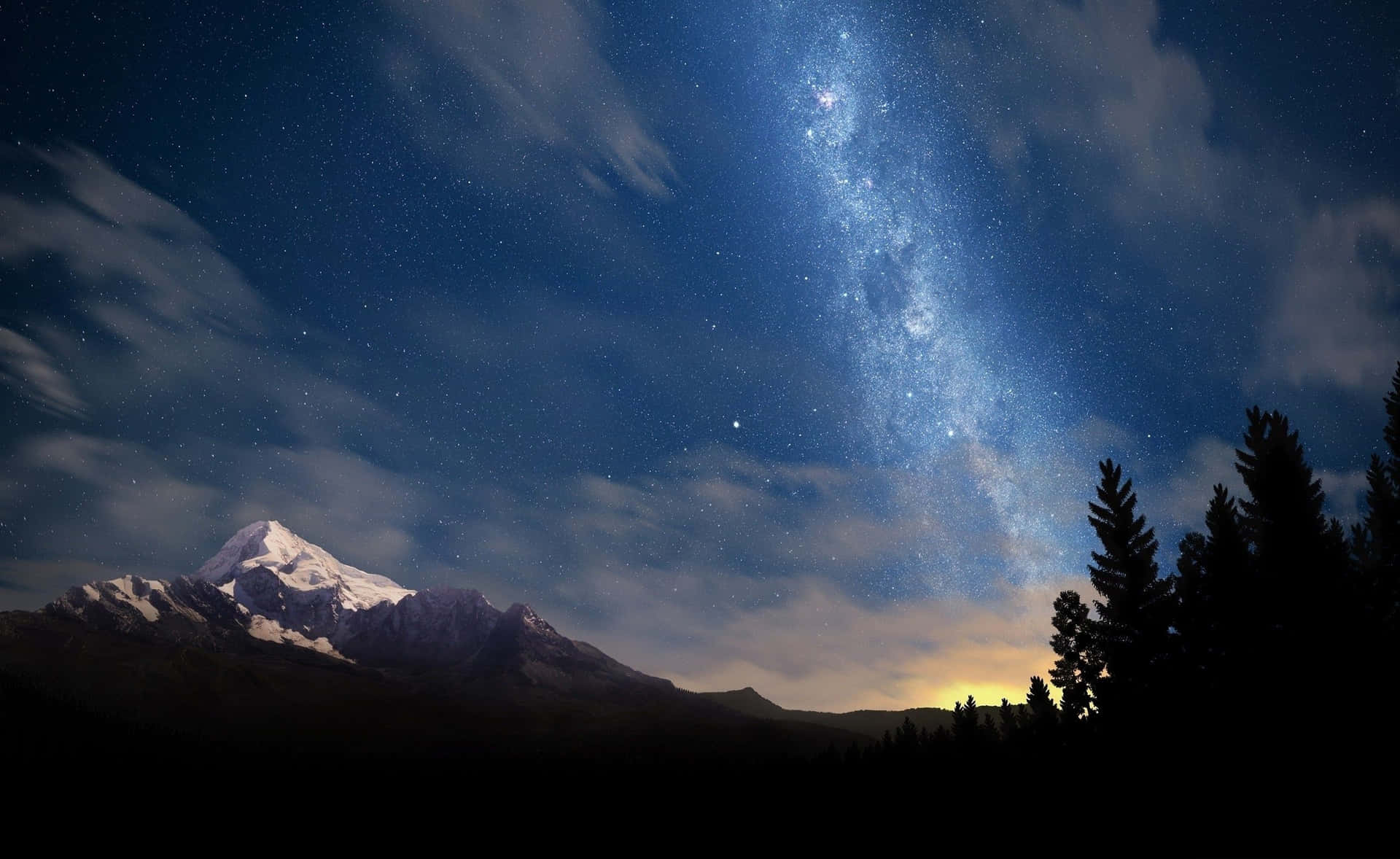 雪山在星空下，銀河與樹木剪影