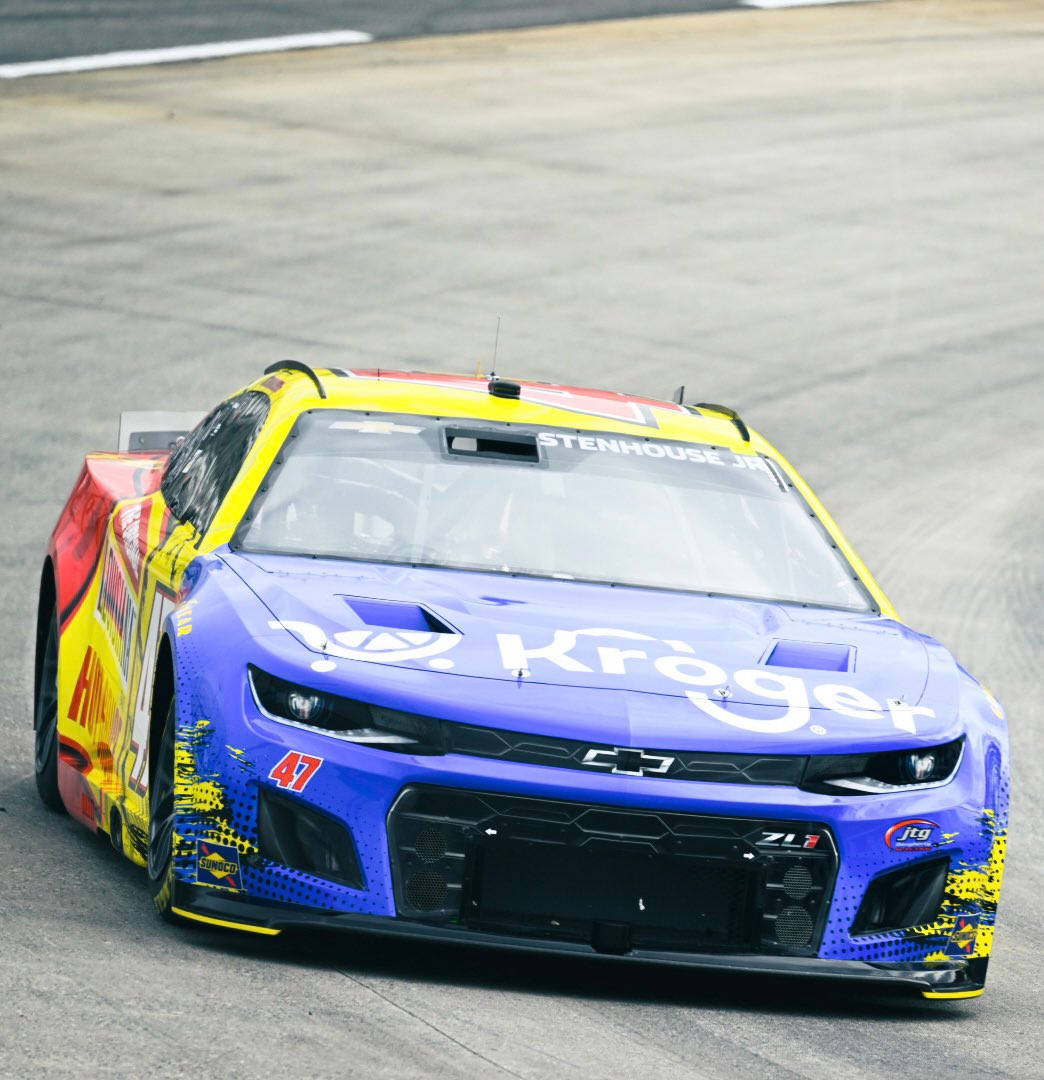 帶有Kroger標誌的藍黃色NASCAR賽車在賽道上疾馳。