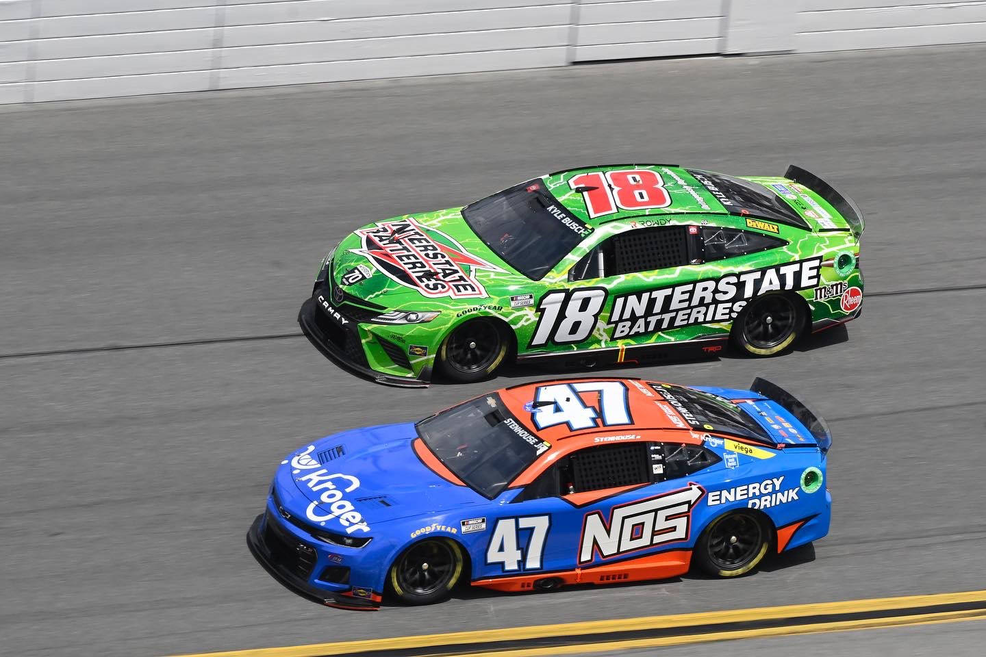 兩輛NASCAR賽車在賽道上並排比賽。