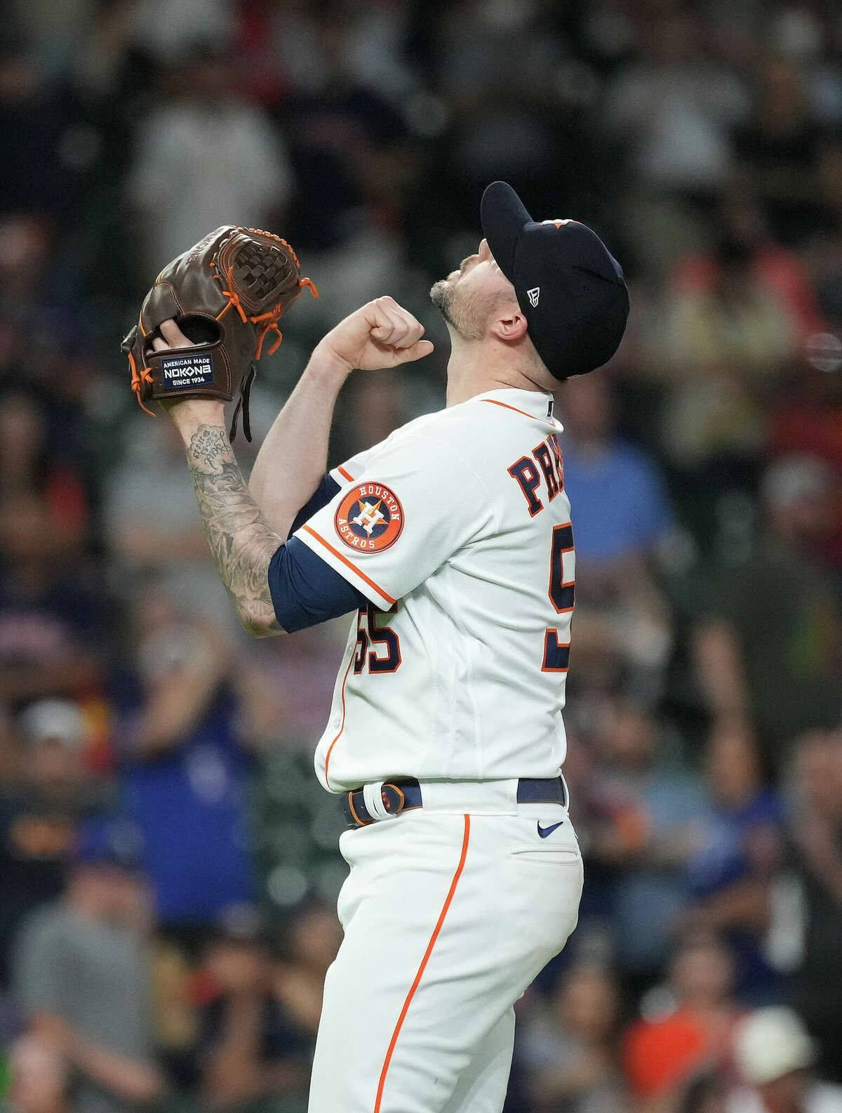 棒球投手在夜間比賽中高舉拳頭和手套慶祝勝利。