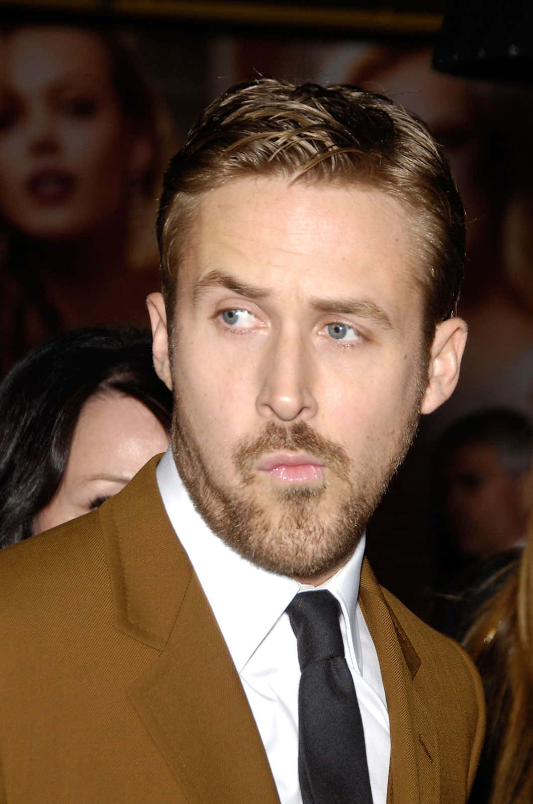 賴恩高斯寧在正式活動中穿著棕色西裝和黑色領帶。