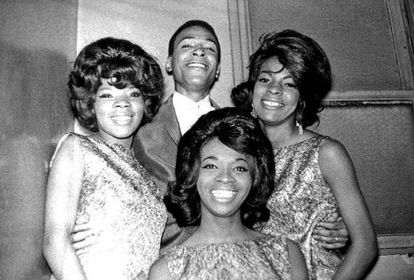 瑪莎與范戴爾斯與馬文·蓋伊 壁紙 — 四位微笑的至上女聲組合（The Supremes）成員身穿1960年代華麗服裝，在室內素牆前緊密擺姿勢。