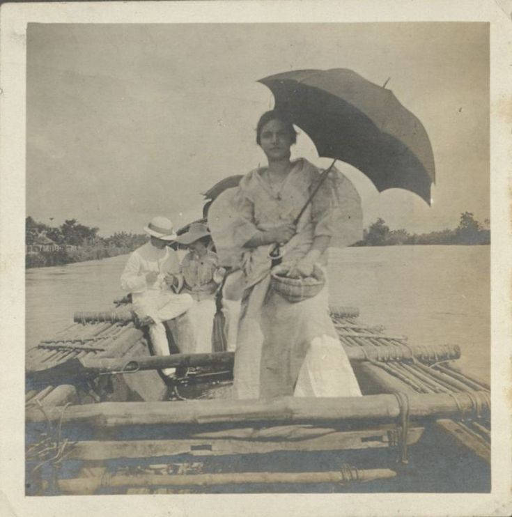 女子手持雨傘和籃子，與孩子們在竹筏上，河流