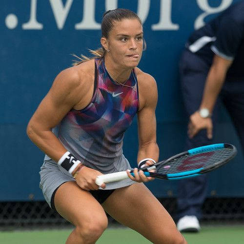 女網球運動員穿著運動服裝準備在球場上擊球。
