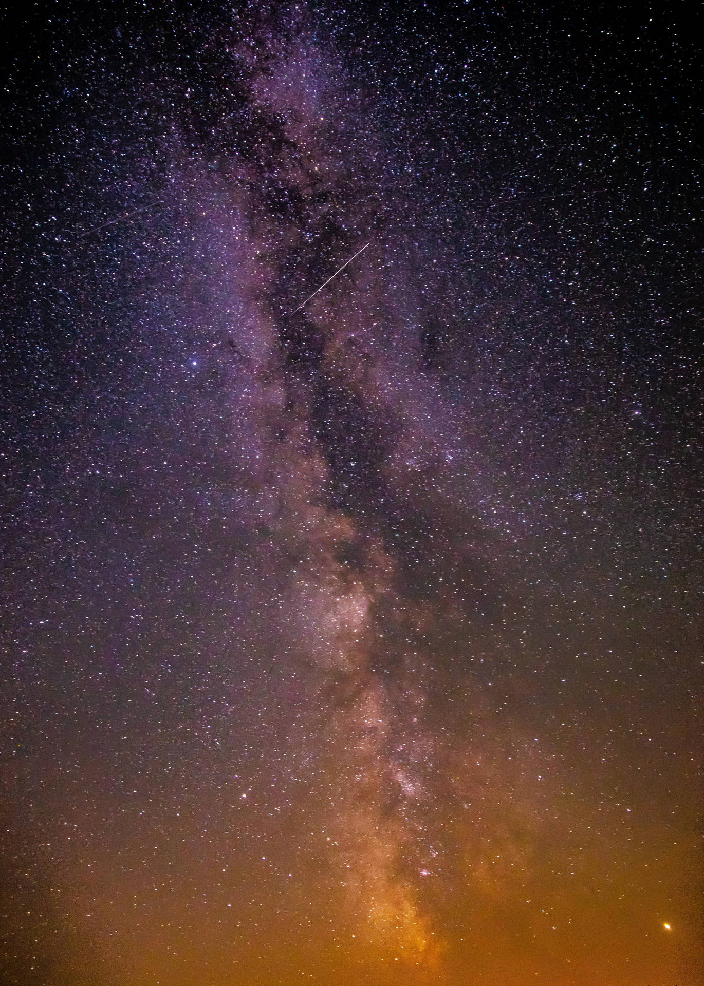 銀河系在漆黑的夜空中閃爍著星星和一顆流星。