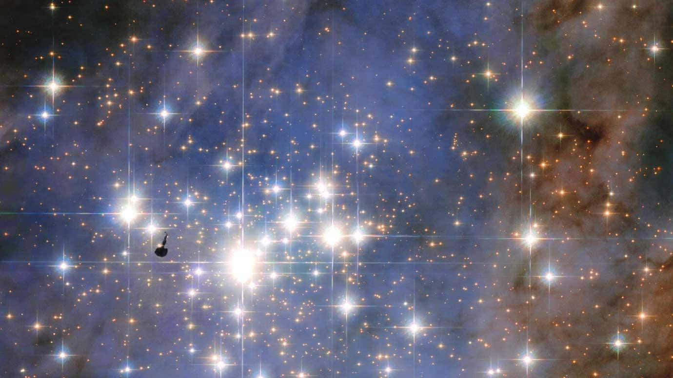 璀璨星空天文攝影 壁紙 — 一個令人眼花繚亂的星場，有明亮的星星和宇宙塵埃雲，在深藍色和橙色色調中發光。