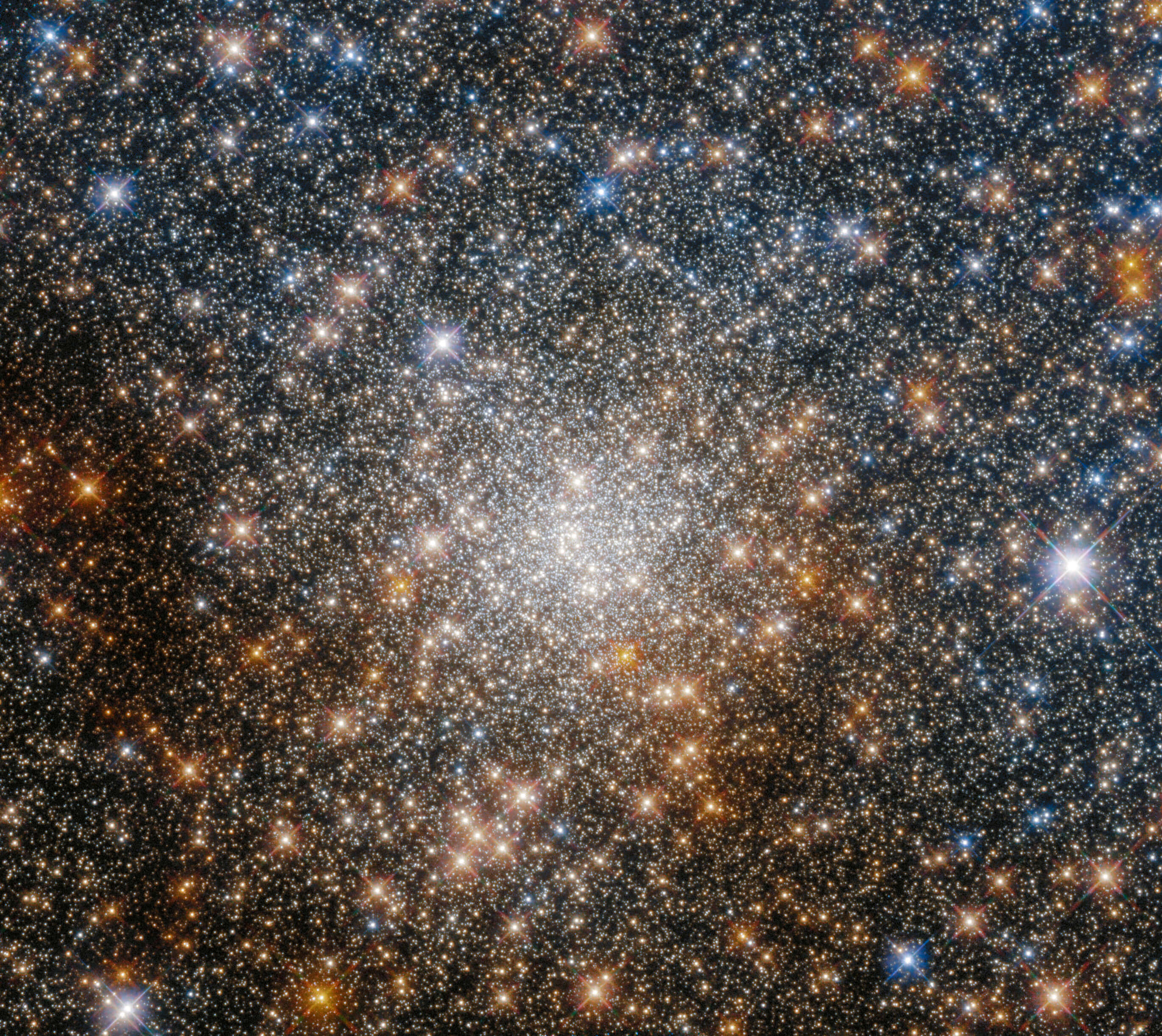 璀璨星辰點綴夜空 壁紙 — 密集的星團在黑暗的宇宙背景下發出鮮豔的藍色和金色光芒。
