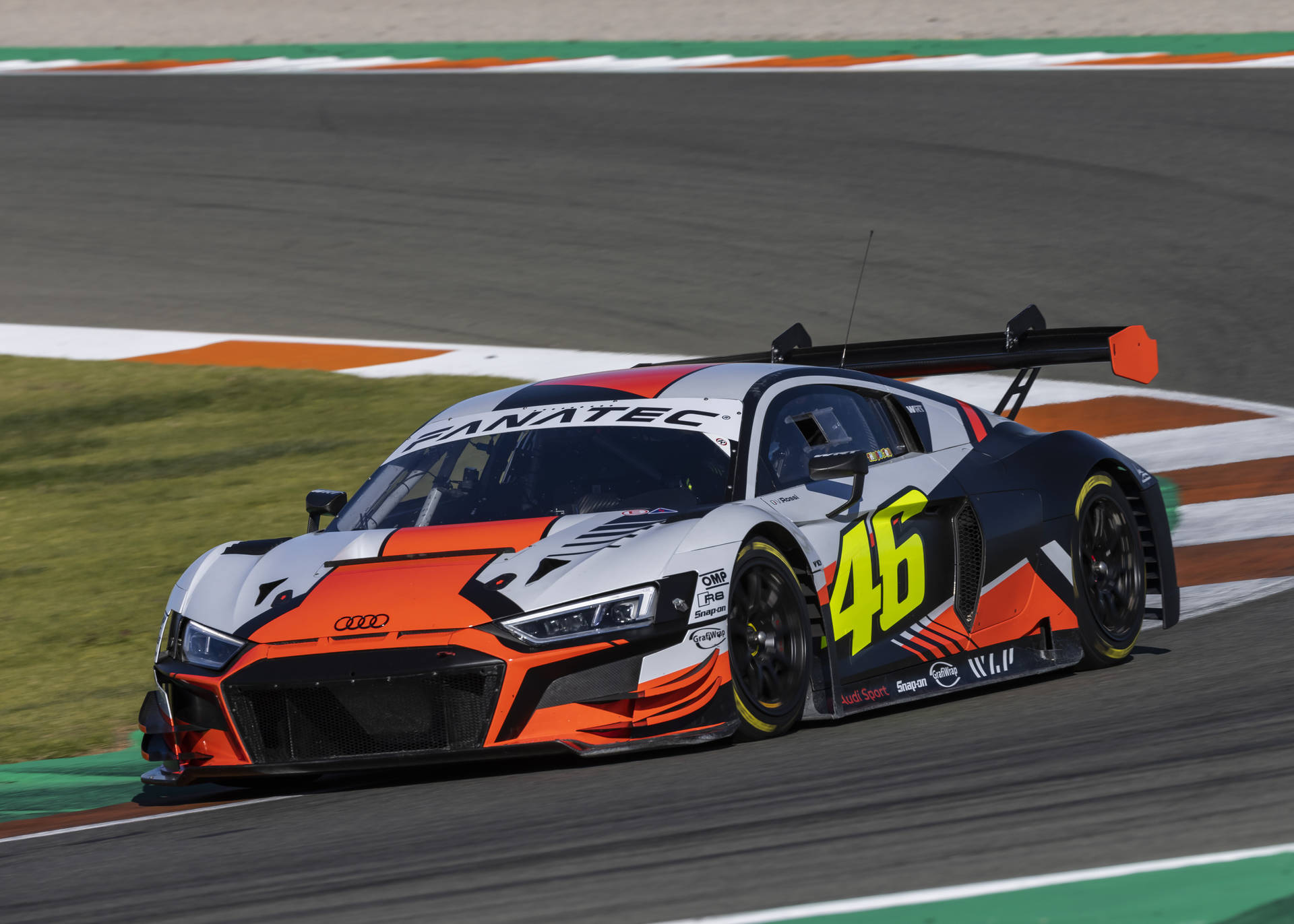 Audi 賽車 46 號在日落時分的賽道上過彎。