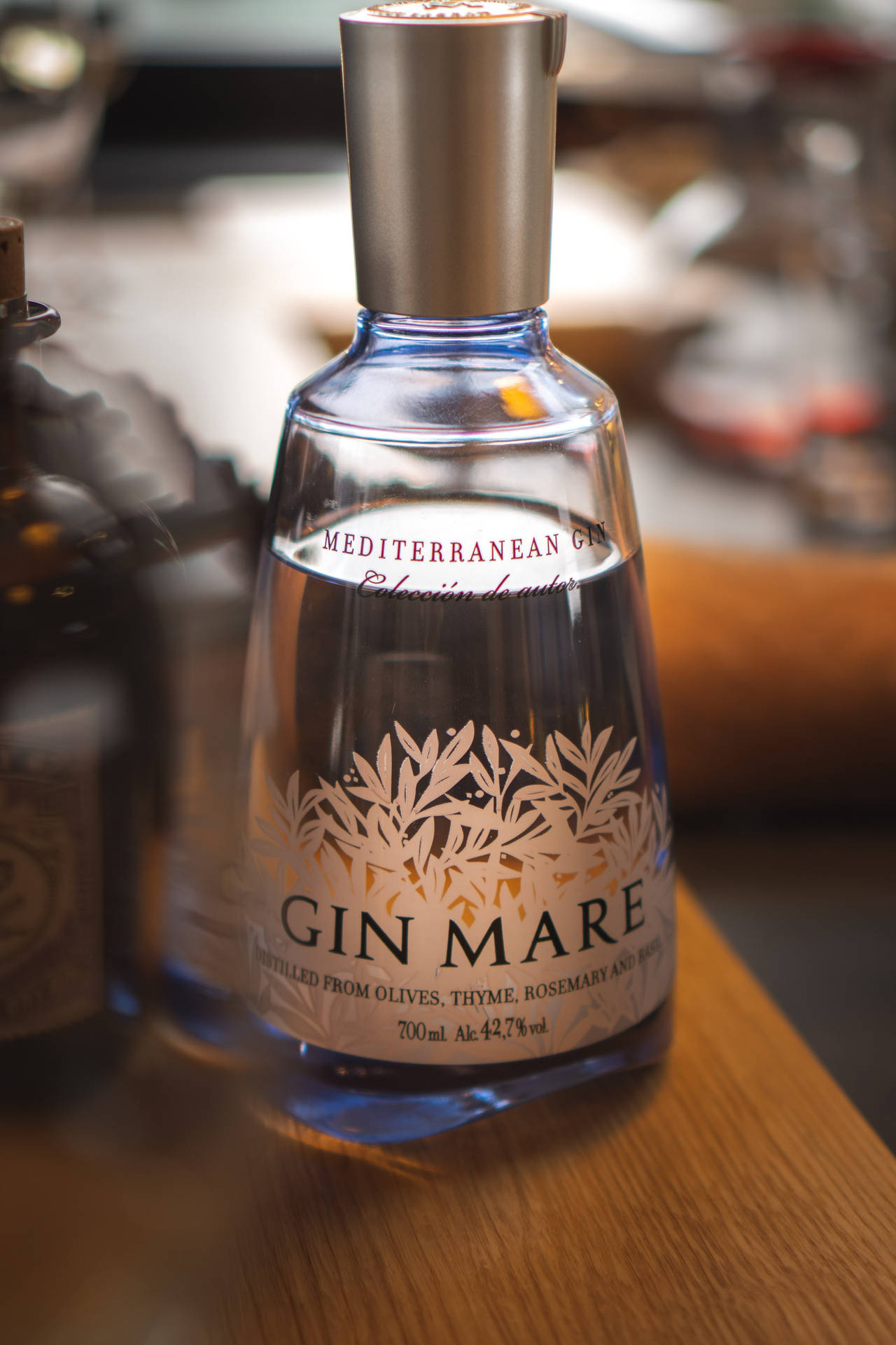 酒吧環境中木桌上的一瓶 Gin Mare 琴酒。