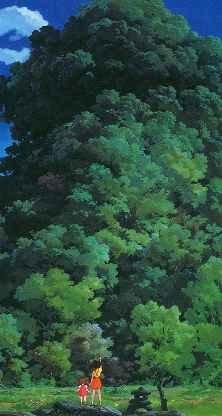 兩個孩子在陽光明媚的林間空地仰望一棵巨樹。