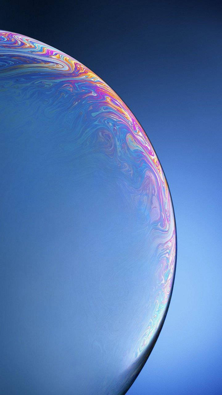 一個在晴朗藍天上漂浮的大型彩色肥皂泡。