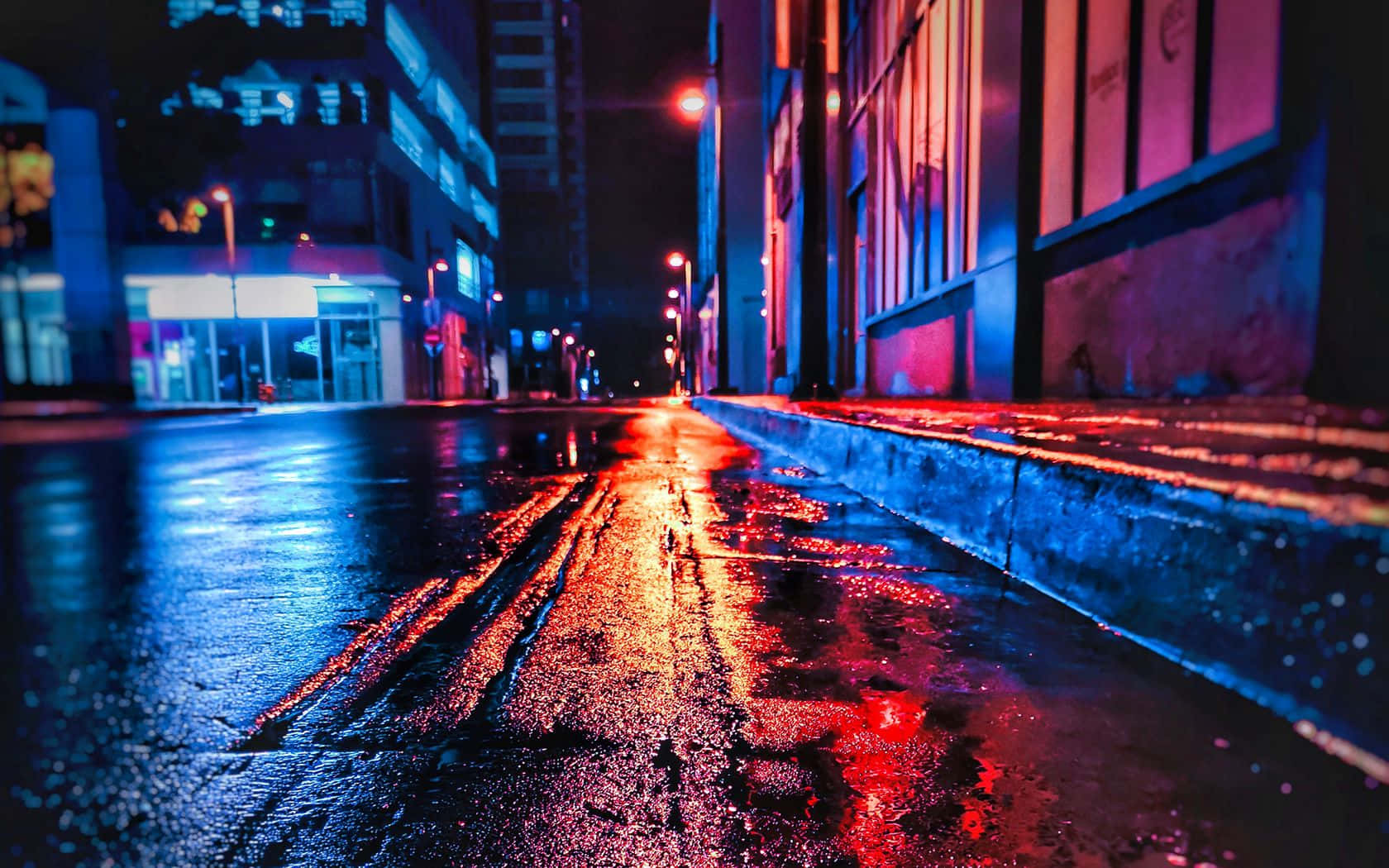 雨濕的城市街道在夜晚閃爍著霓虹燈光。
