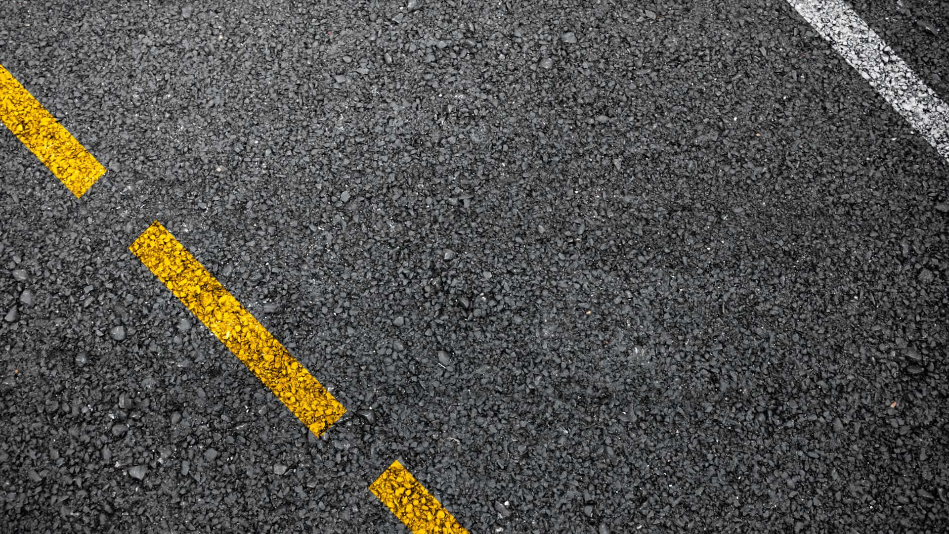 生動的紋理背景 壁紙 — 紋理瀝青道路的特寫，帶有粗體的黃色和白色油漆線標記行車線。