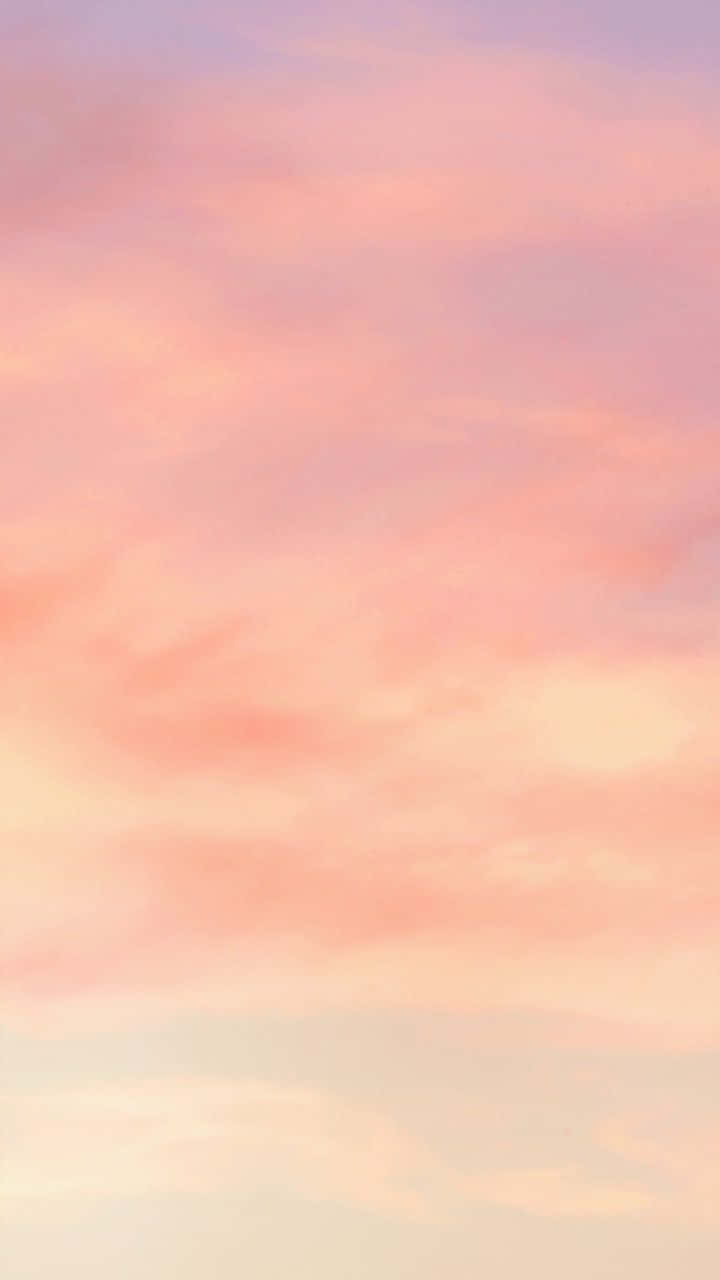 生動的美學色彩 壁紙 — 柔和的粉紅和蜜桃色雲朵在寧靜的暮色天空中飄蕩，帶有柔和的漸變。