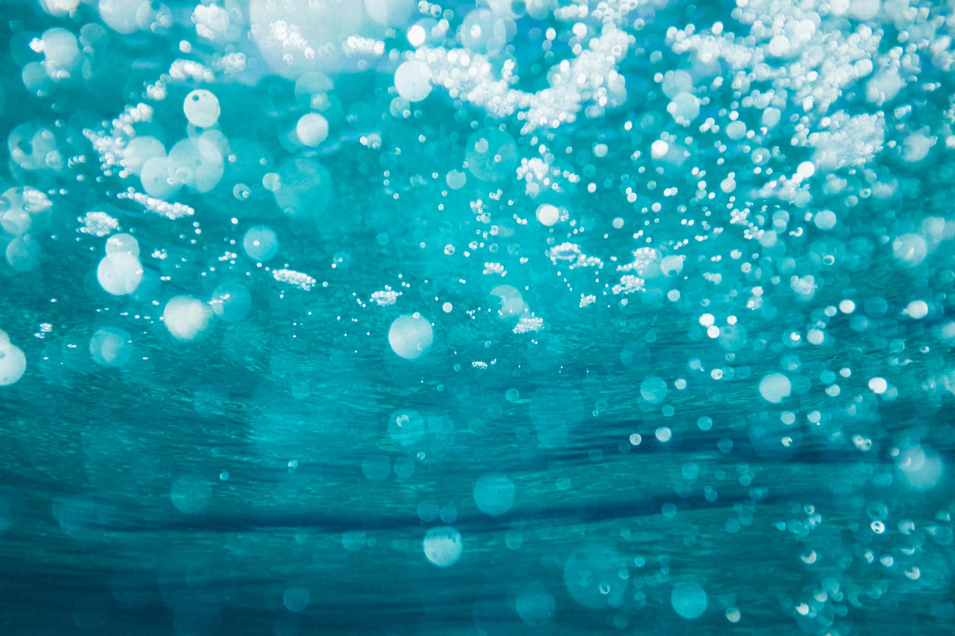 氣泡在清澈碧綠的海水中上升，帶有柔和發光的高光。